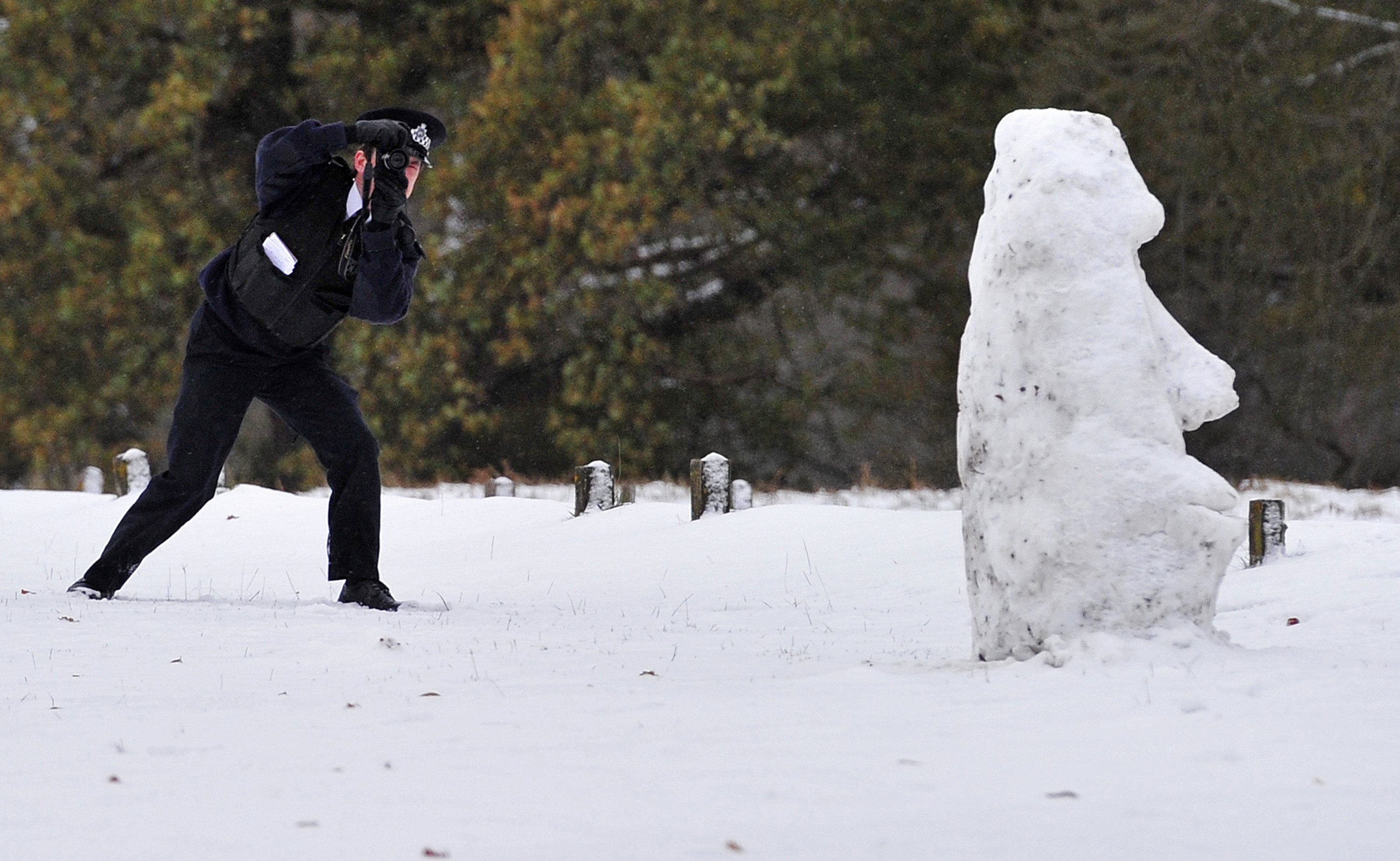 Ο αστυνομικός φωτογραφίζει τον χιονάνθρωπο σε πάρκο του Λονδίνου. ΦΩΤΟ REUTERS