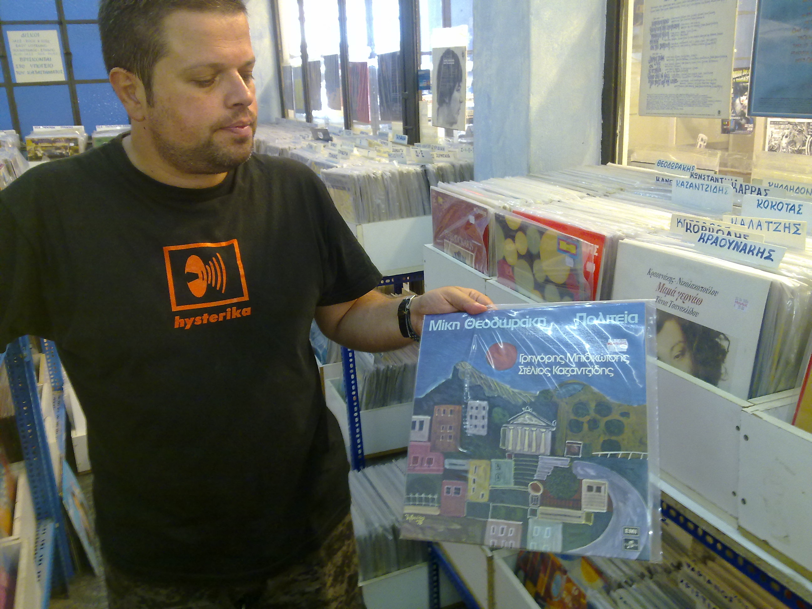 Ο Μανώλης, δείχνει στον φακό του Newsit μεταχειρισμένο δίσκο του Θεοδωράκη που κοστίζει 12,20 ευρώ.