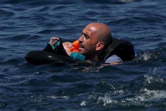 Η φωτογραφία της ημέρας: Πρόσφυγας με μωρό στην αγκαλιά κολυμπάει προς τη Λέσβο