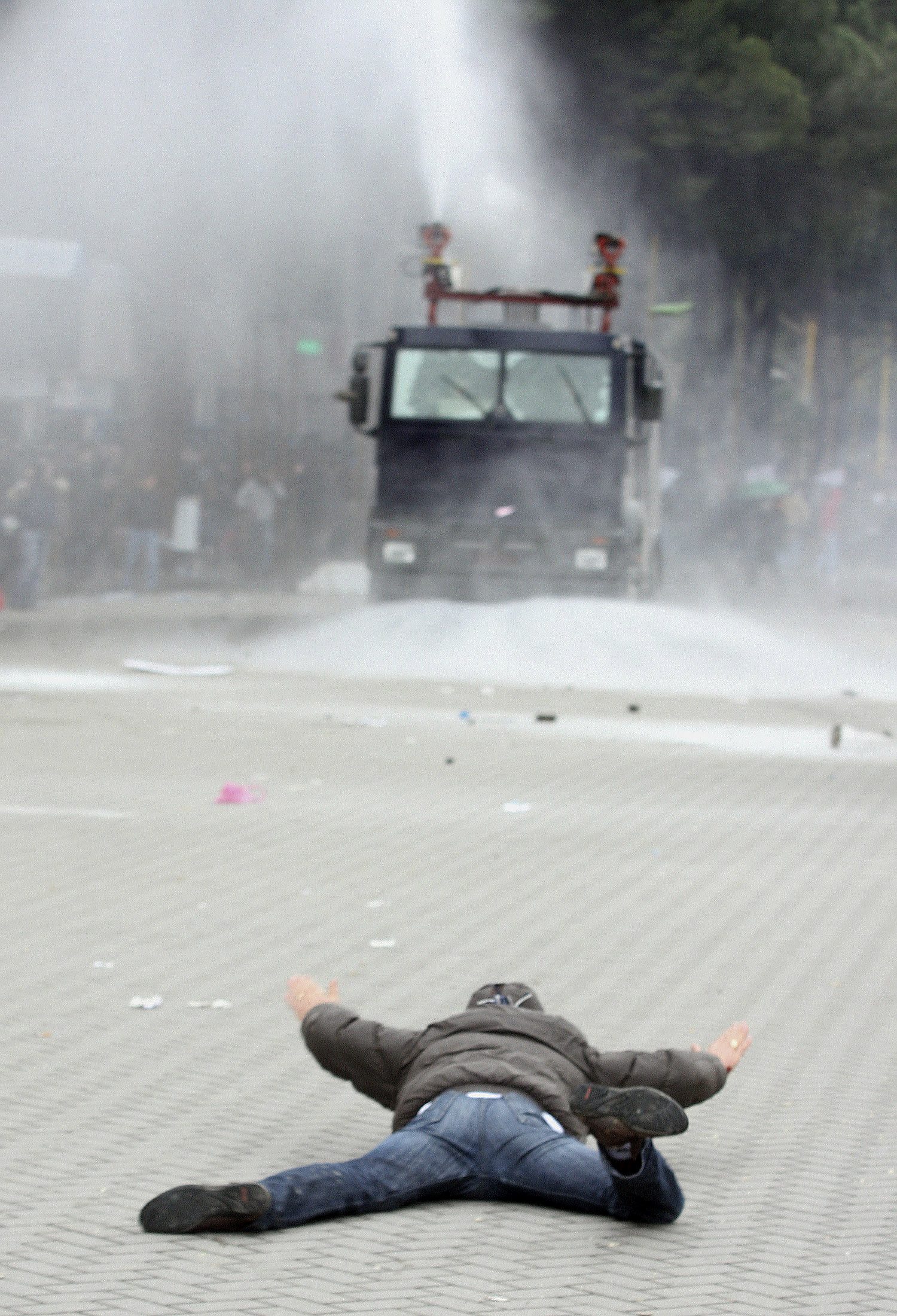 Διαδηλωτής στο έδαφος και στο βάθος οι αστυνομικές δυνάμεις - ΦΩΤΟ REUTERS