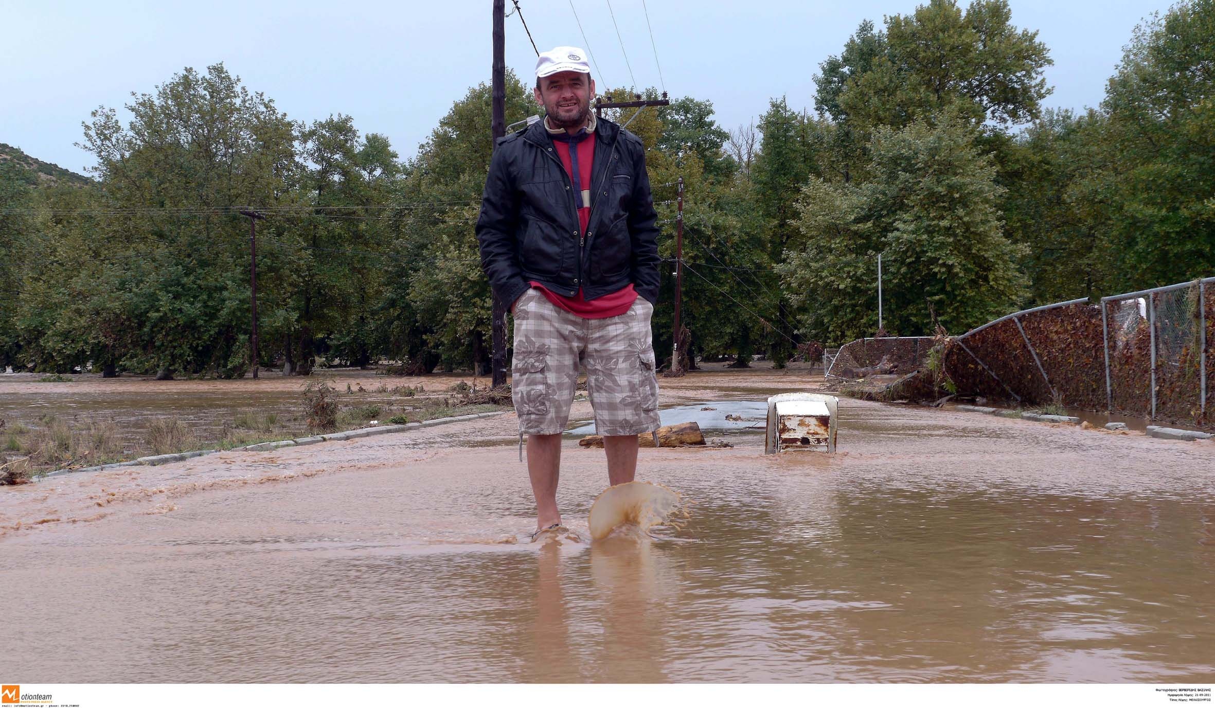 Κάτοικος του χωριού σε έναν από τους πλημμυρισμένους δρόμους - ΦΩΤΟ EUROKINISSI