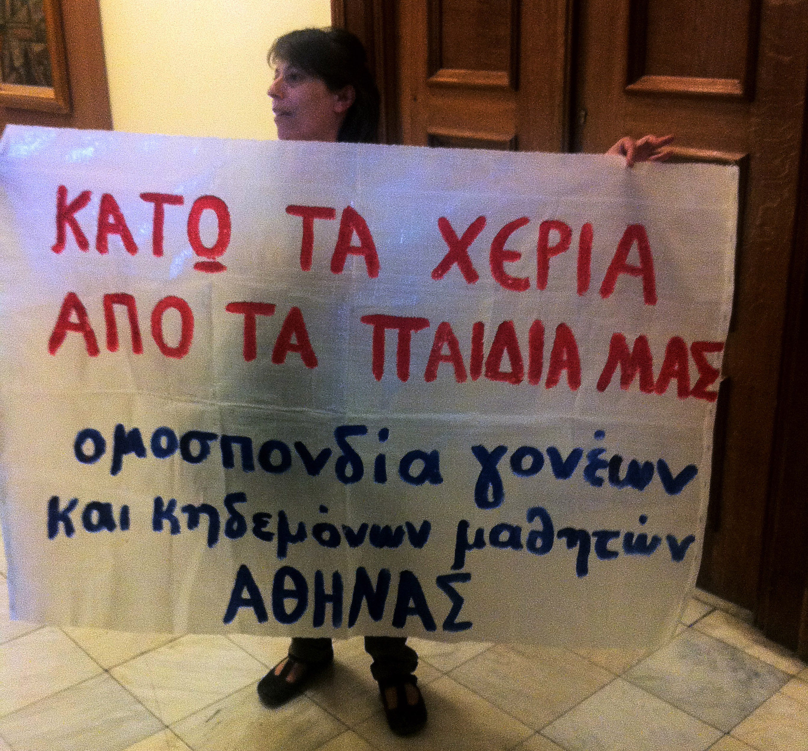 H κυρία Αθανασοπούλου με το επίμαχο πανό μέσα στο Κοινοβούλιο 