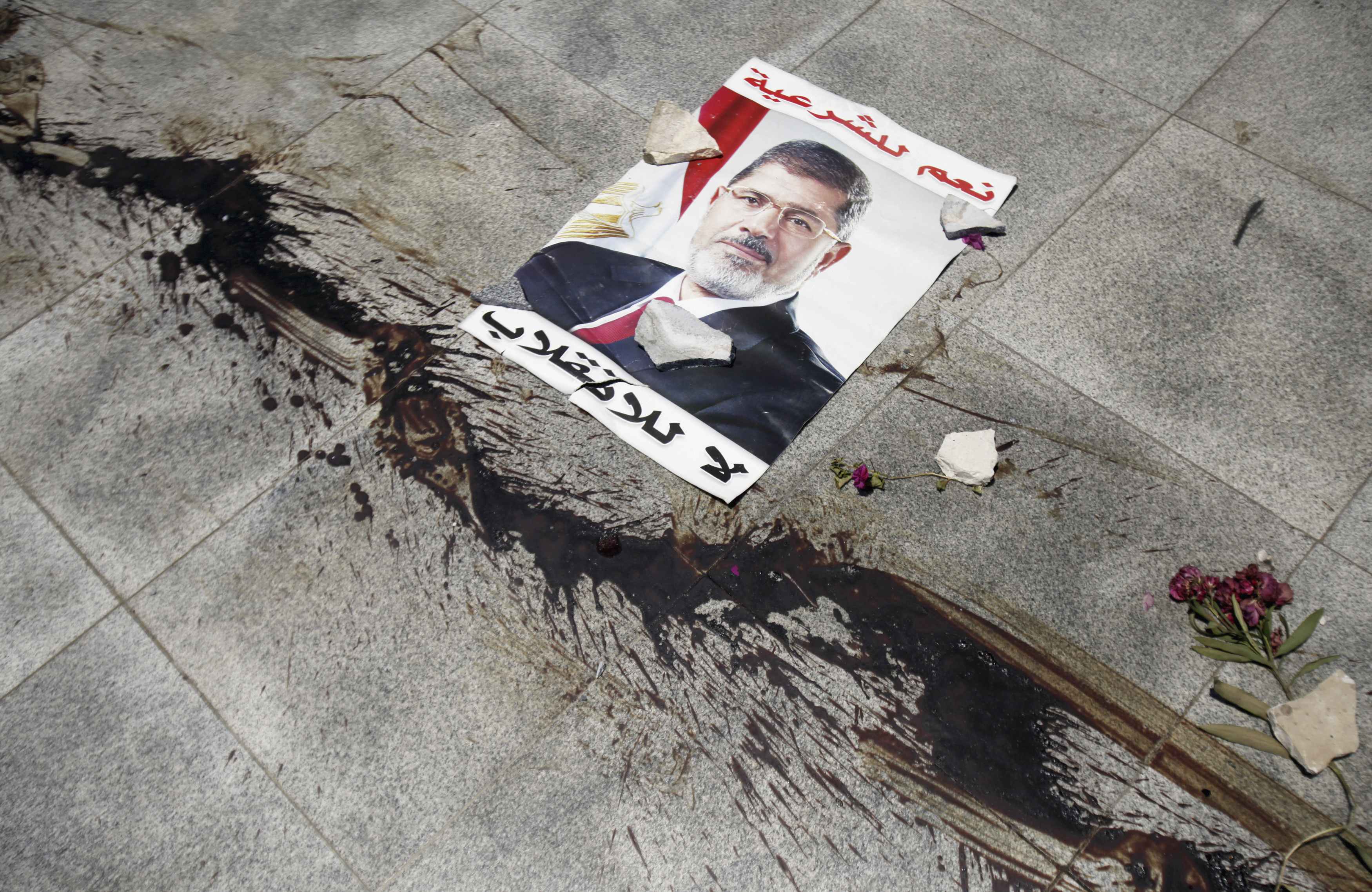 Οι δρόμοι γεμάτοι αίμα από τη χθεσινή σφαγή - Με φόντο τον Μόρσι - ΦΩΤΟ REUTERS