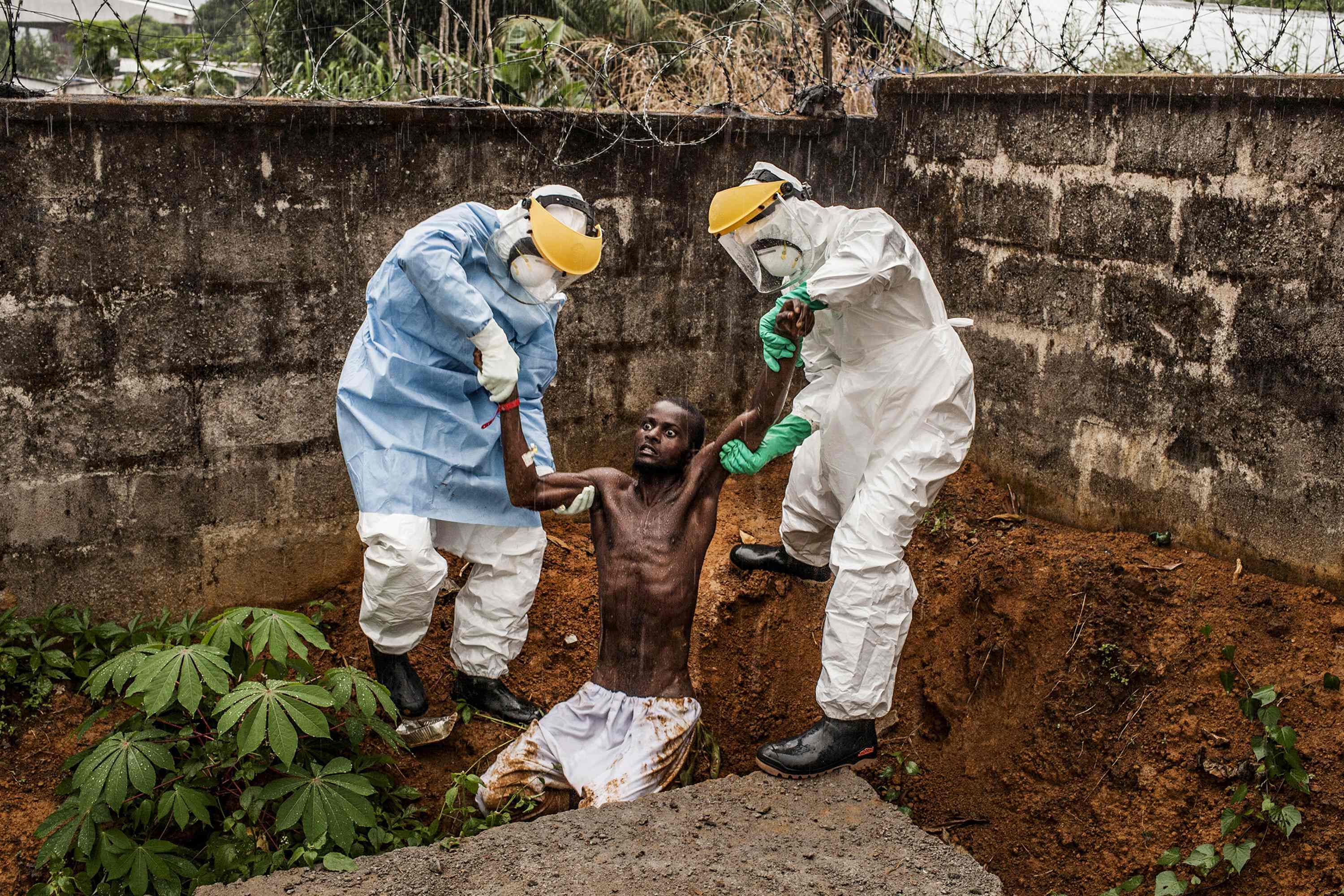 Pete Muller | Ιατρικό προσωπικό στο Ebola Treatment Center συνοδεύει ασθενή με παραλήρημα πίσω στον θάλαμο απομόνωσης από όπου δραπέτευσε στο Freetown