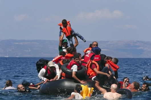 Ένας άνδρας σηκώνει στον αέρα ένα παιδί - ΦΩΤΟ REUTERS