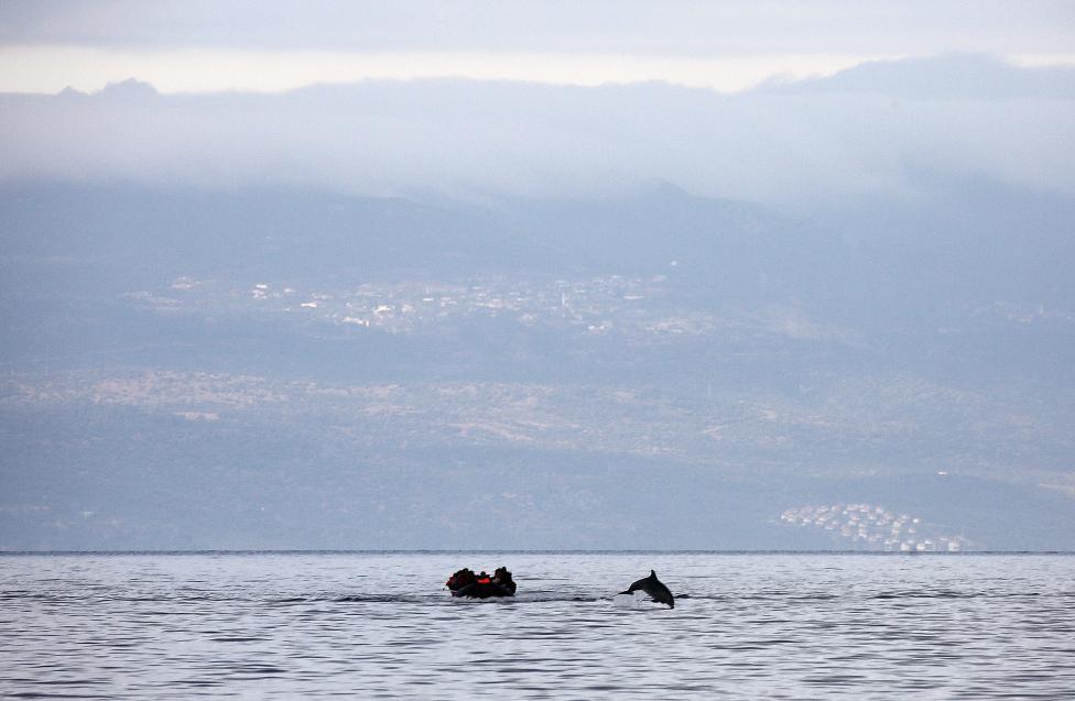 68. Λέσβος, Τετάρτη 21 Οκτωβρίου Ένα δελφίνι πηδά μπροστά από μια σχεδία, πάνω στην οποία βρίσκονται Σύροι πρόσφυγες και περνούν από την Τουρκία στη Λέσβο. 