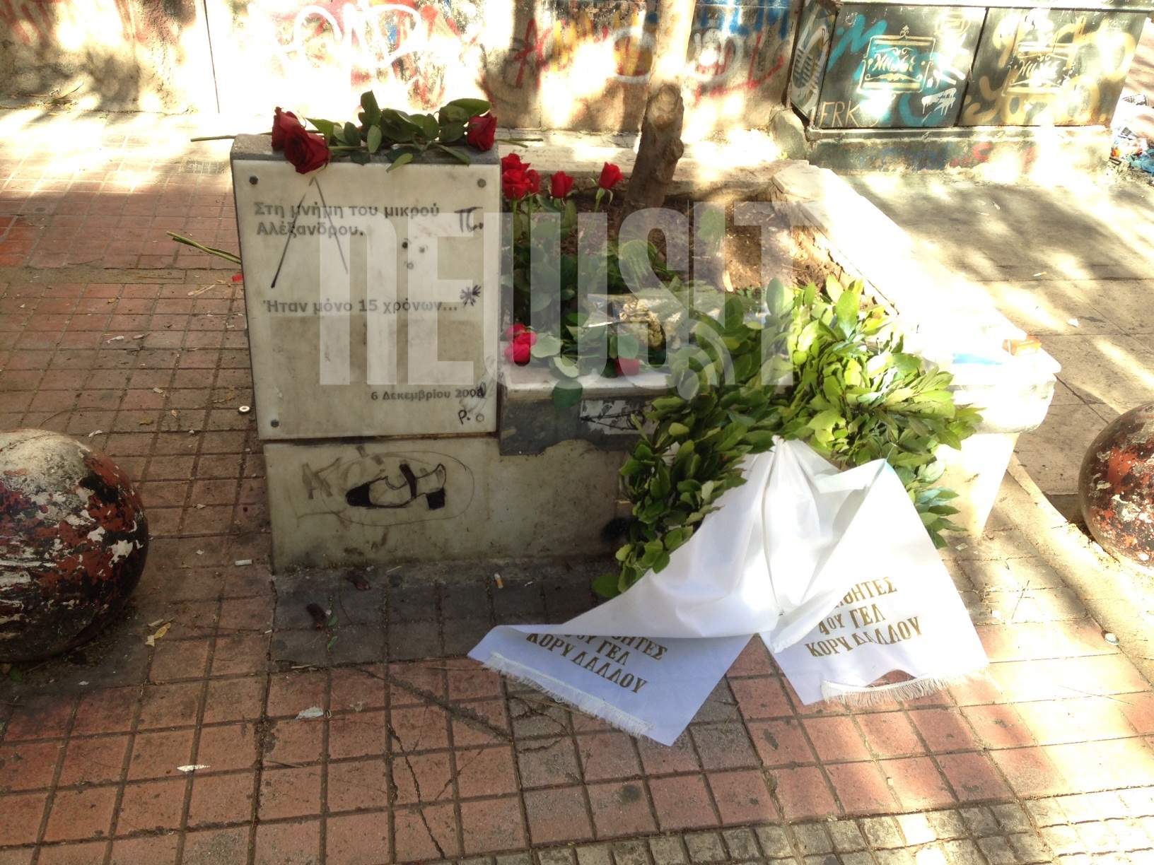 Περαστικοί και μαθητές αφήνουν ένα λουλούδι στο σημείο που δολοφονήθηκε ο Αλέξης Γρηγορόπουλος στα Εξάρχεια - ΦΩΤΟ NEWSIT