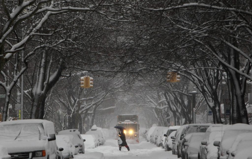 Ολα στα λευκά και το εκχιονιστικό στο βάθος σε κεντρικό δρόμο της Νεας Υόρκης! ΦΩΤΟ REUTERS