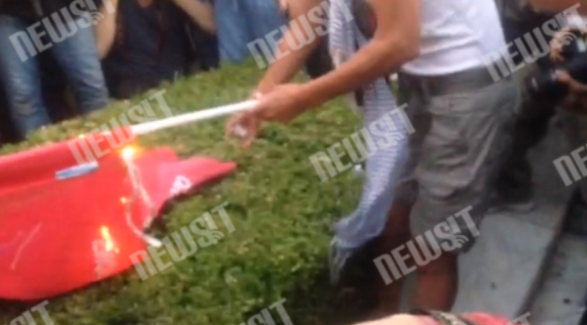 Διαδηλώτρια καίει σημαία ΣΥΡΙΖΑ