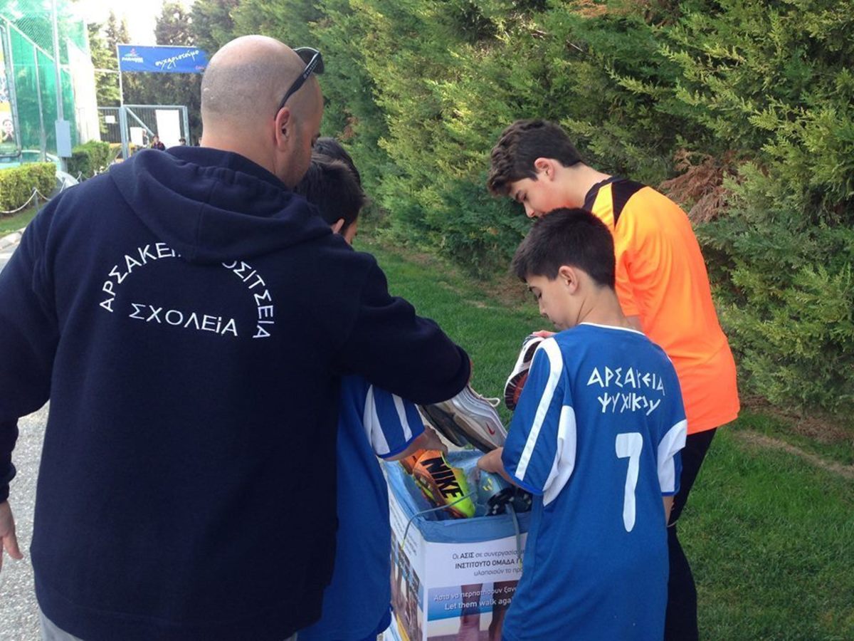 Τα παιδιά αθλούνται και προσφέρουν τα παπούτσια τους για βοήθεια