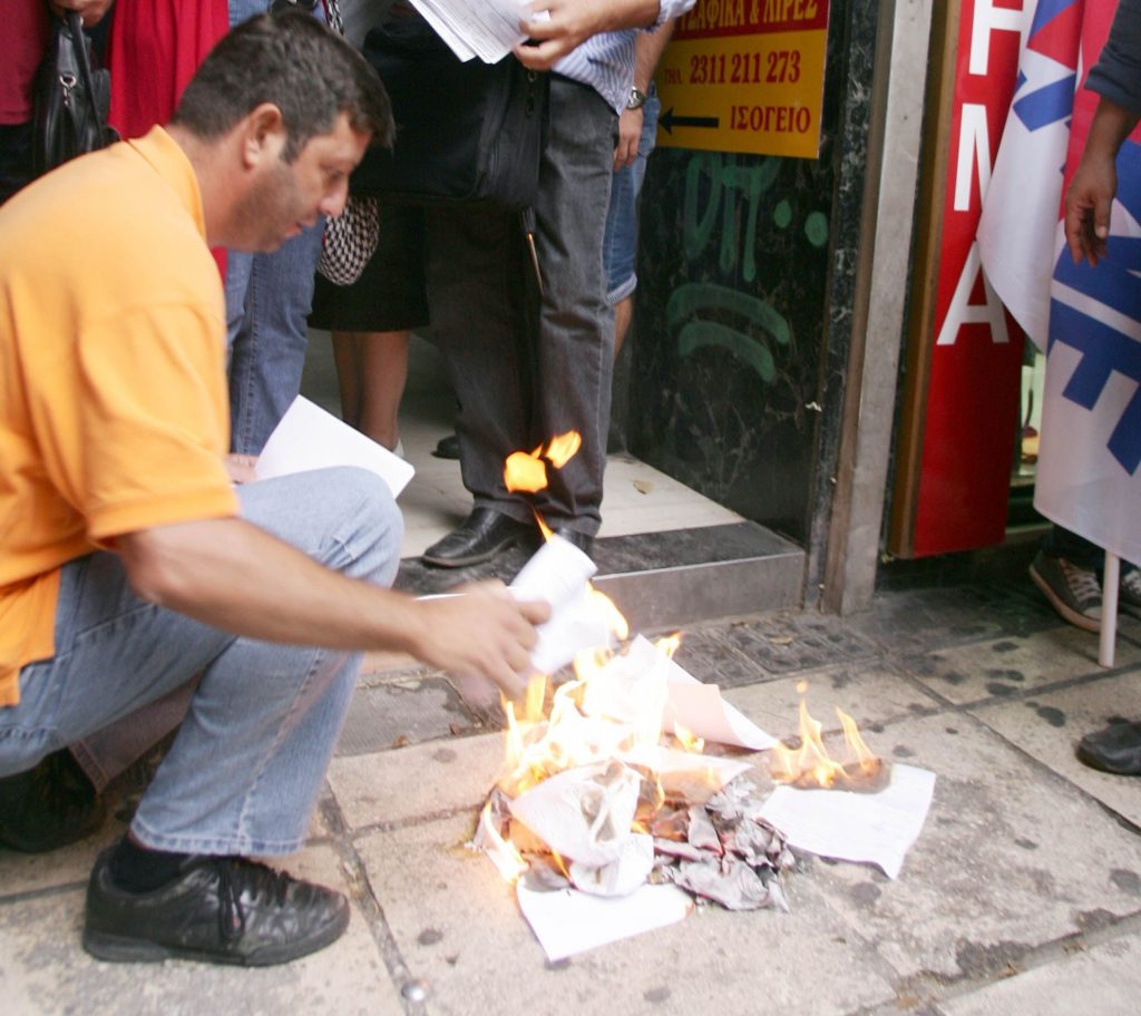 Μέλη του ΠΑΜΕ καίνε τα σημειώματα - ΦΩΤΟ EUROKINISSI