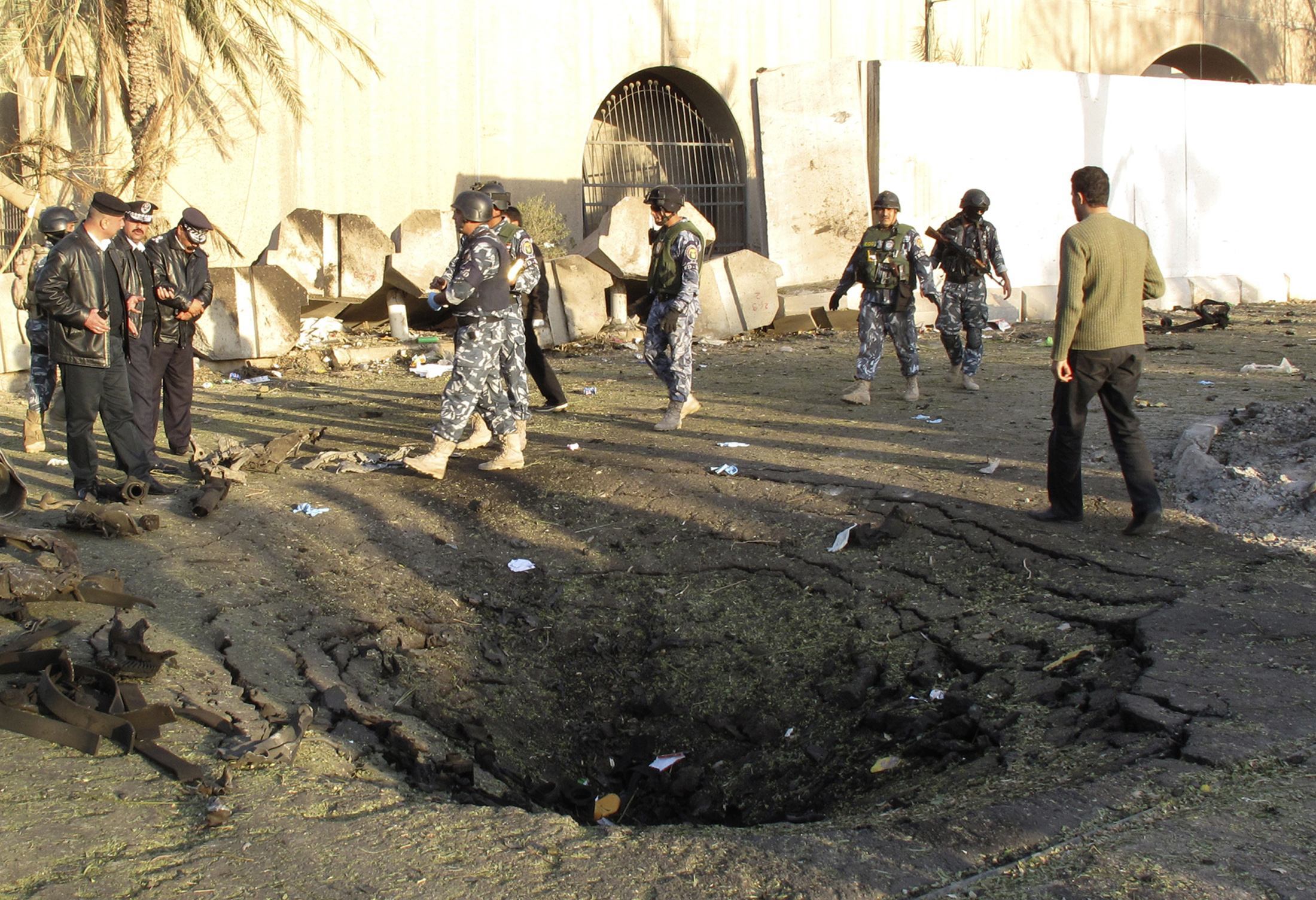 Οι αστυνομικοί μαζεύονται σε ένα από τα σημεία της βομβιστικής επίθεσης στην Βαγδάτη. ΦΩΤΟ REUTERS