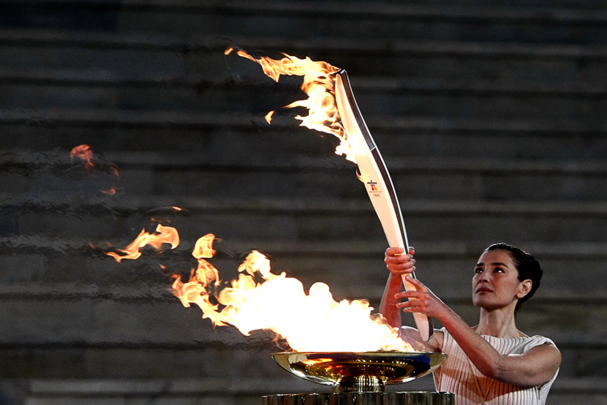 Факел современные игры зажигается. Зажжение олимпийского огня в Греции 2014. Факел эстафеты олимпийского огня. Олимпийский огонь Сочи 2014.
