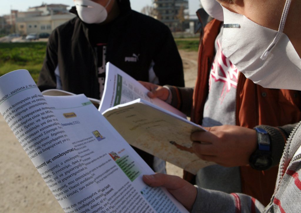 Μαθητές με μάσκες διαβάζουν έξω από το κλειστό σχολείο ΦΩΤΟ EUROKINISSI