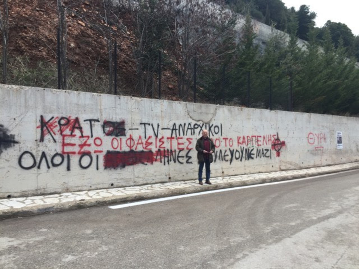 Ο Δημήτρης Ζώτος μπροστά από το σύνθημα που έσβησε