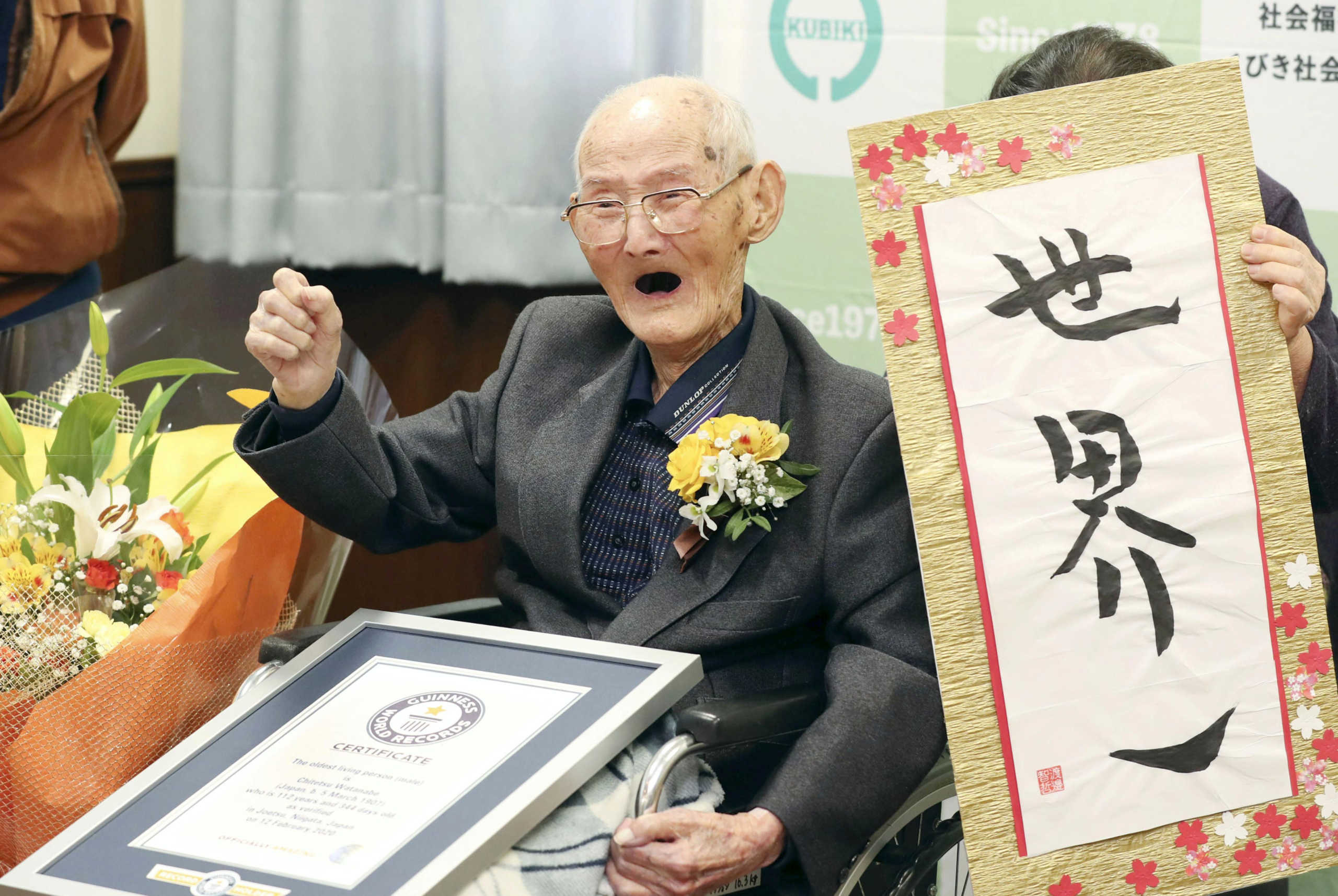 112-year-old Chitetsu Watanabe poses next to the calligraphy reading 'World's Number One' after being awarded as the world's oldest living male by Guinness World Records, in Joetsu, Niigata prefecture, northern Japan February 12, 2020, in this photo released by Kyodo.  Mandatory credit Kyodo