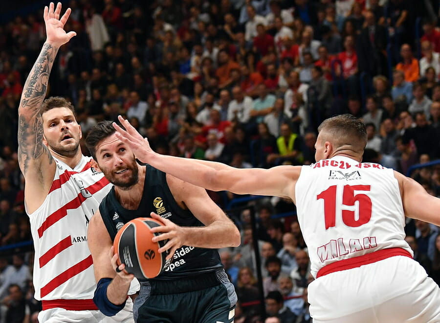 epa07100952 Real Madrid Rodolfo Fernandez Farres (C) drives up to the basket against Armani Exchange Milano Kaleb Tarczewski (R)and Vladimir Micov during their Euroleague basketball match at the Assago Forum, Milan, Italy, 17 October 2018.  EPA