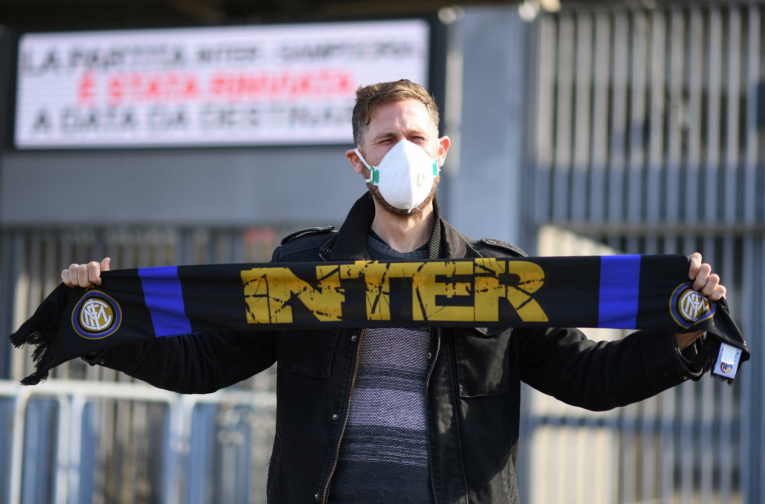 A man wearing a face mask stands outside the San Siro stadium after the Inter Milan v Sampdoria Serie A match was cancelled due to an outbreak of the coronavirus in Lombardy and Veneto, in Milan, Italy, February 23, 2020.REUTERS