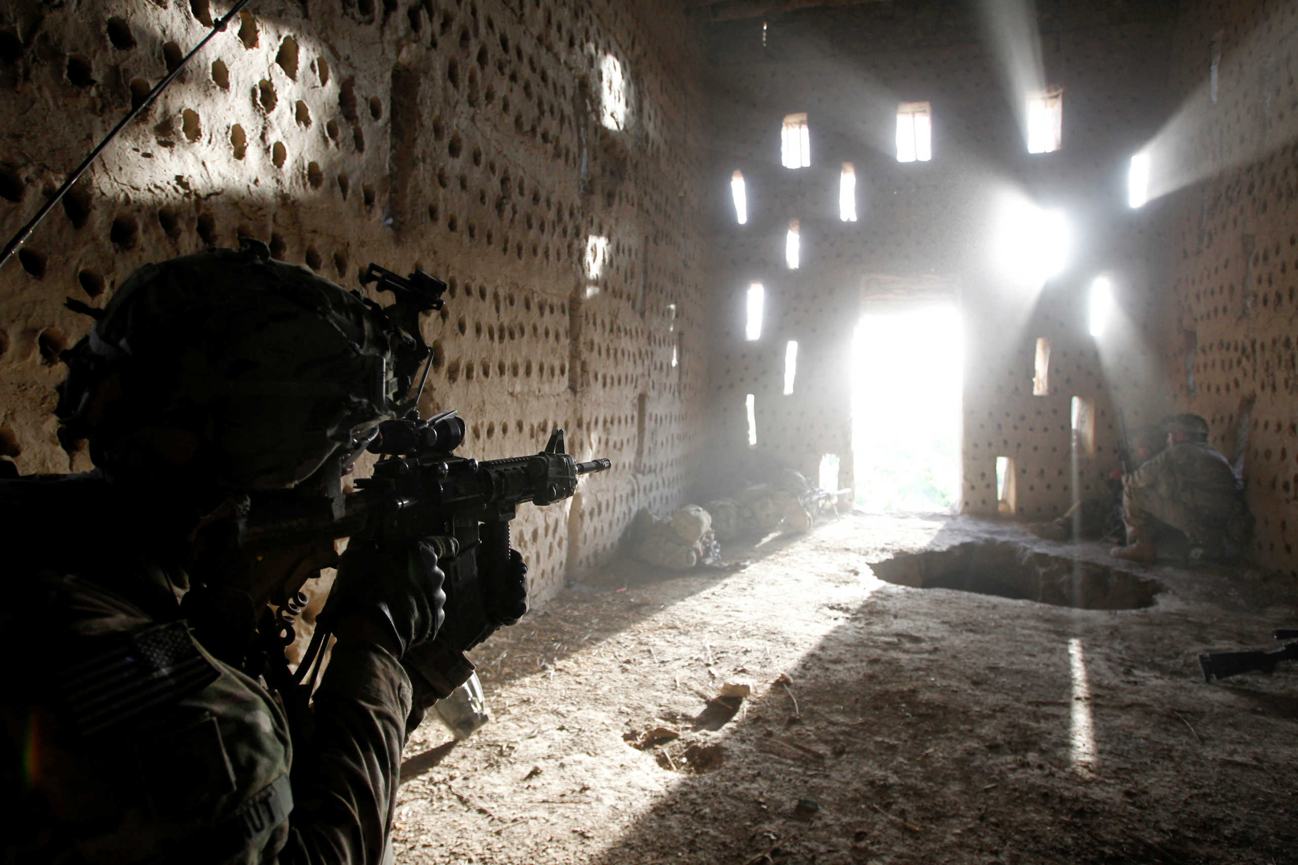 FILE PHOTO: U.S. soldier Nicholas Dickhut from 5-20 infantry Regiment attached to 82nd Airborne points his rifle at a doorway after coming under fire by the Taliban while on patrol in Zharay district in Kandahar province, southern Afghanistan April 26, 2012. REUTERS