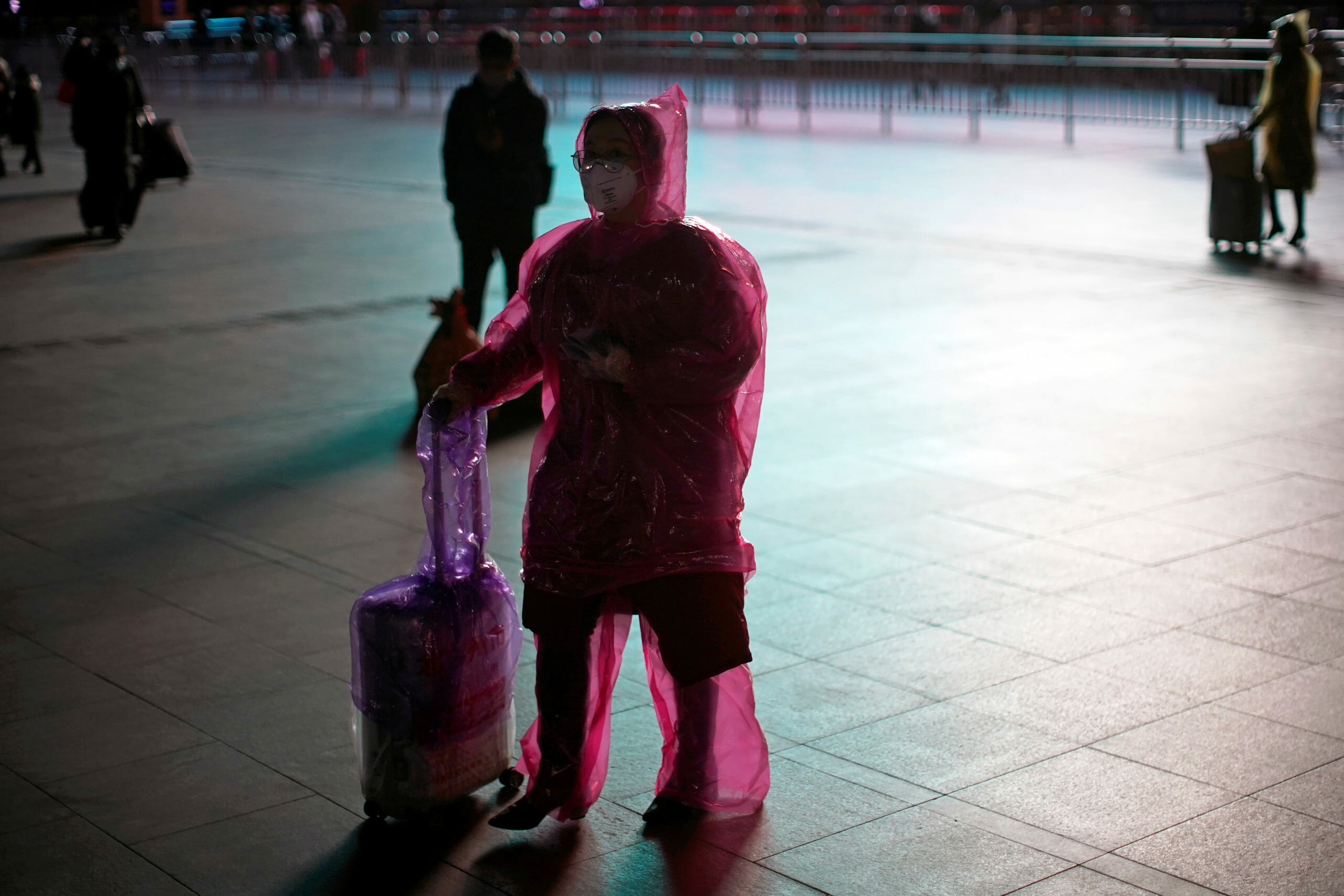 A woman wears a face mask and plastic raincoat as a protection from coronavirus at Shanghai railway station, in Shanghai, China February 17, 2020. REUTERS