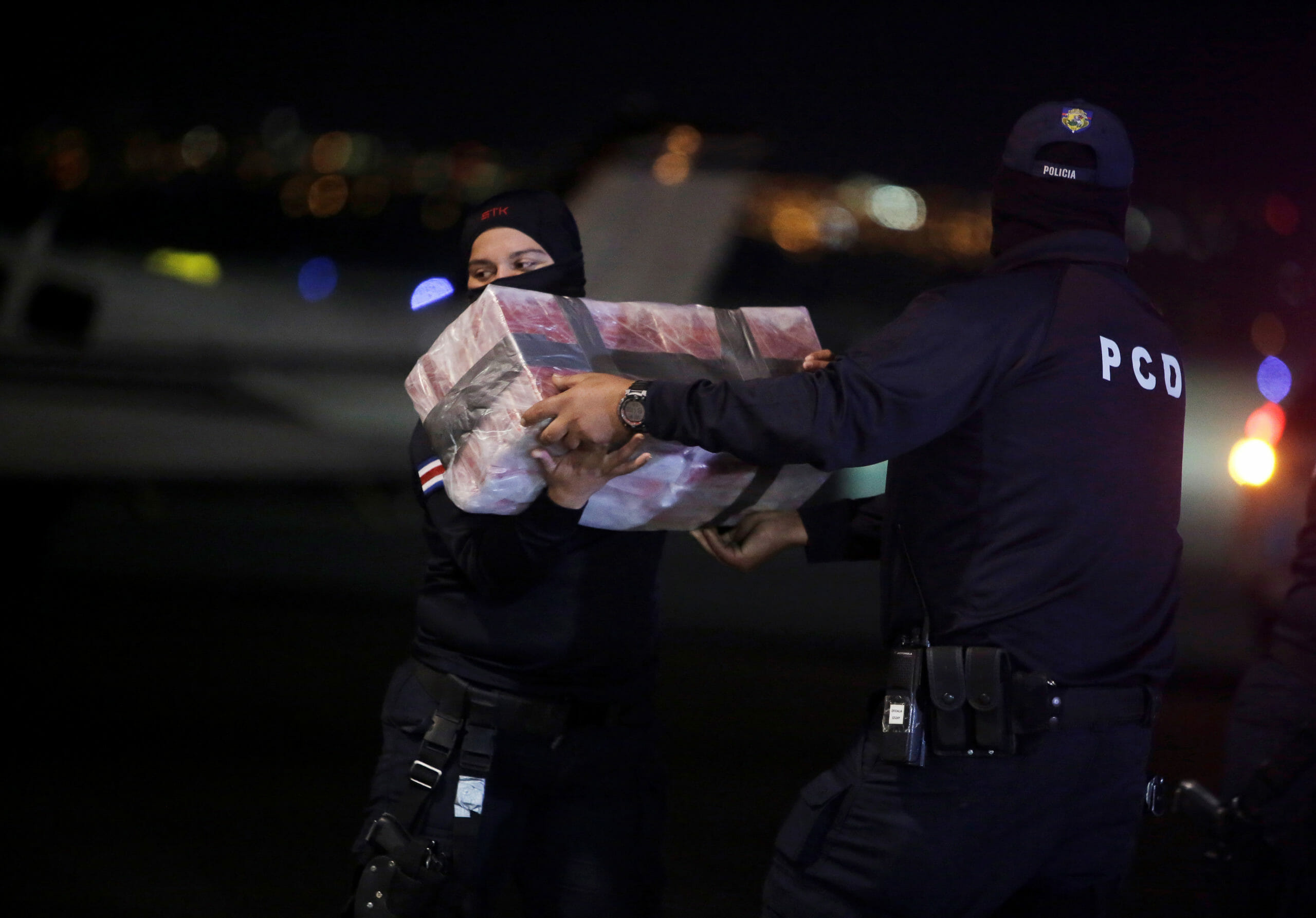 Police officers carry packages containing cocaine seized during an operation in the Caribbean, at the air base of the Ministry of Security in Alajuela, Costa Rica, February 15, 2020. REUTERS