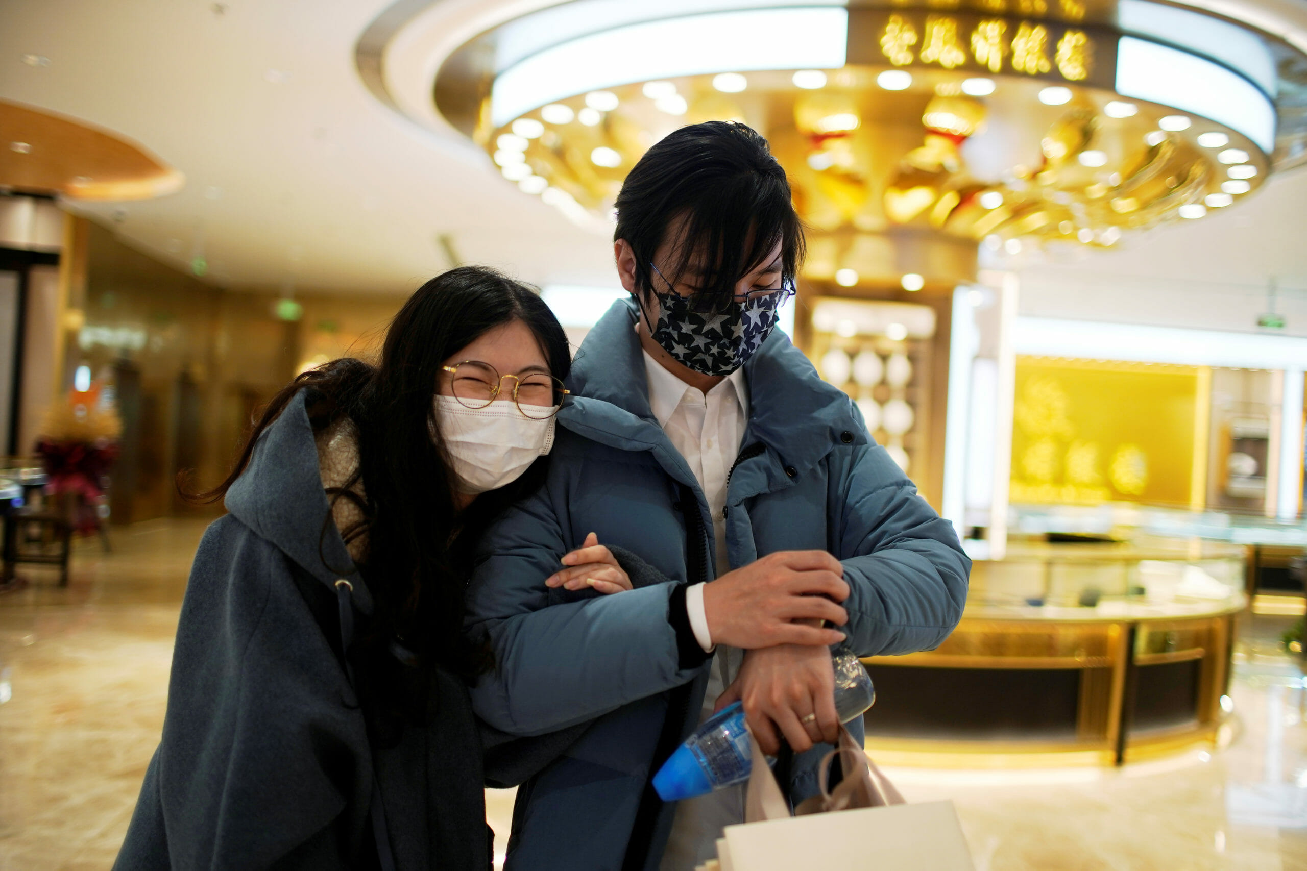 Wang, 32, and his wife Shi, 30, wearing masks are seen walking at a shopping mall on Valentine's Day in Shanghai, China, as the country is hit by an outbreak of the novel coronavirus, February 14, 2020. REUTERS