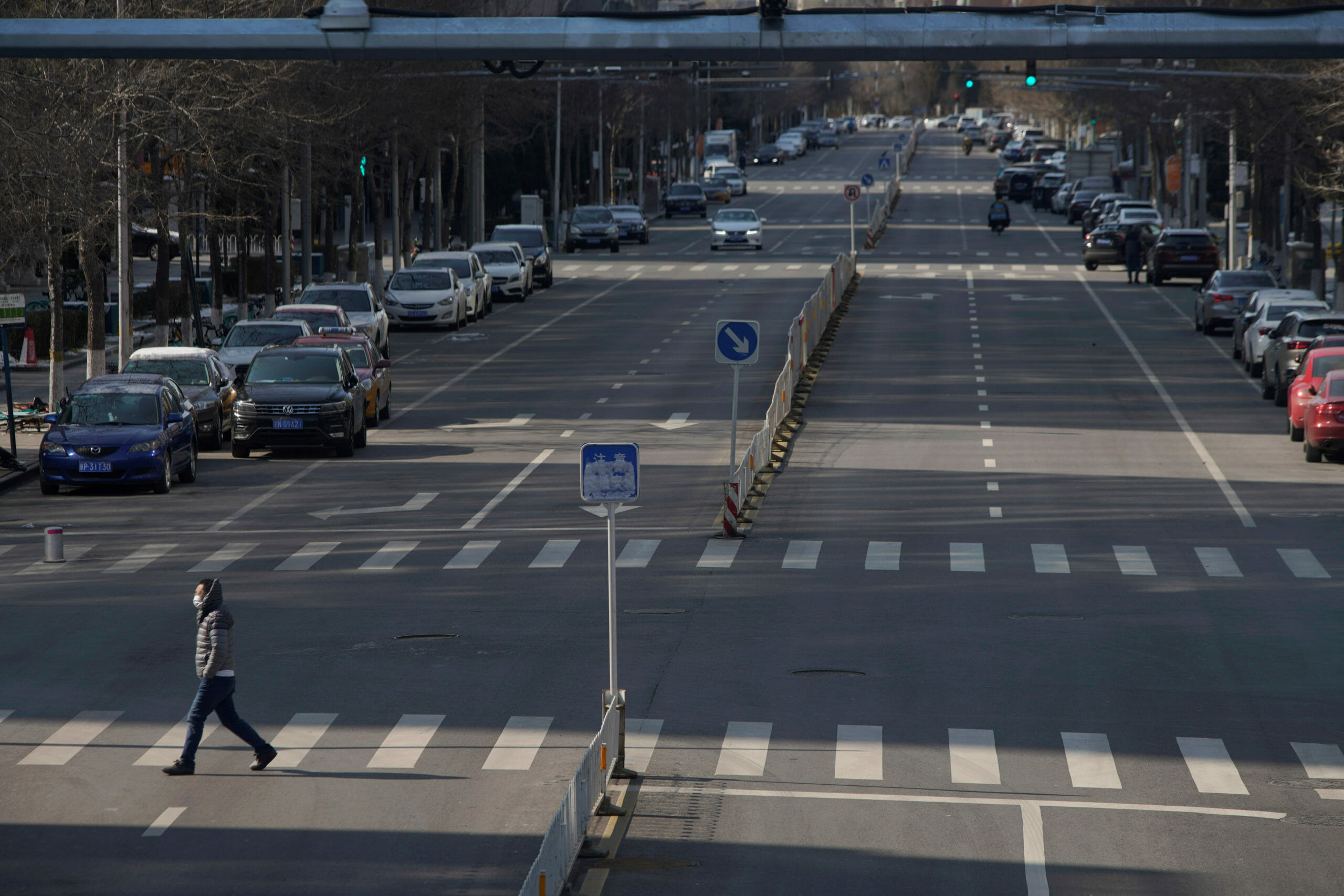 A man wearing a face mask crosses a road, as the country is hit by an outbreak of the novel coronavirus, in Beijing, China February 15, 2020. REUTERS