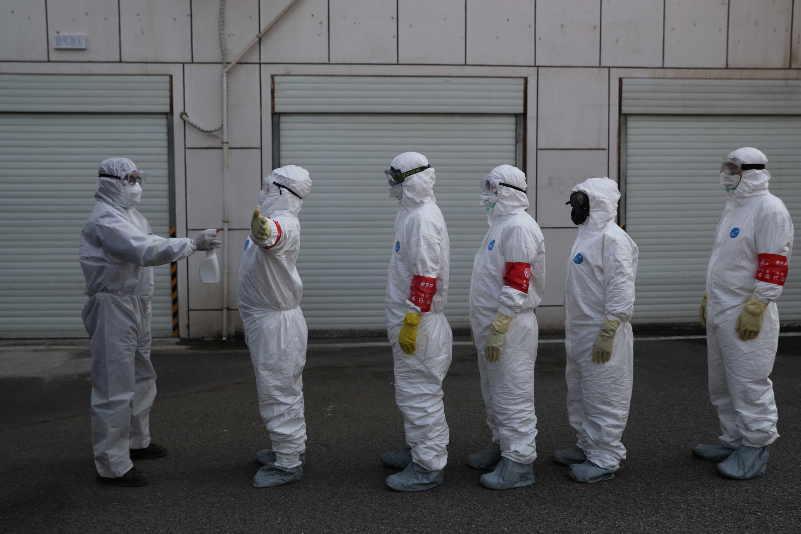 Volunteers in protective suits are being disinfected in a line in Wuhan, the epicentre of the novel coronavirus outbreak, in Hubei province, China February 22, 2020. Picture taken February 22, 2020. China Daily via REUTERS ATTENTION EDITORS - THIS IMAGE WAS PROVIDED BY A THIRD PARTY. CHINA OUT.