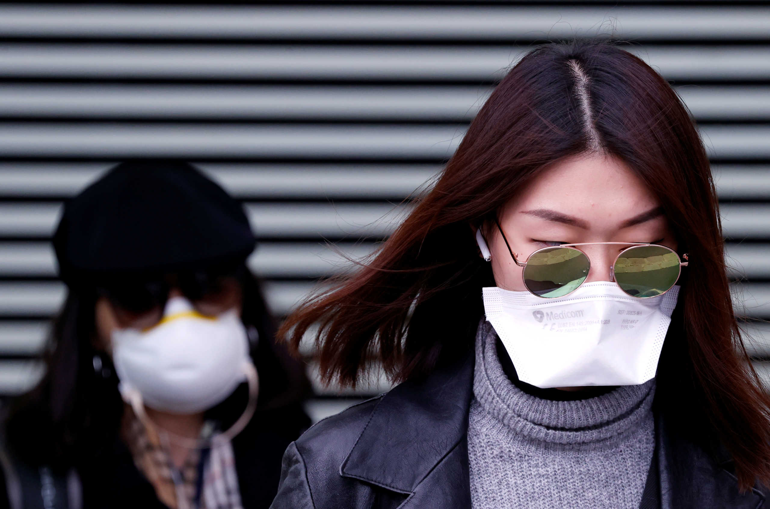 Women wearing face masks leave XIII district police station in Paris, after a suspected coronavirus case was examined, France February 24, 2020. REUTERS