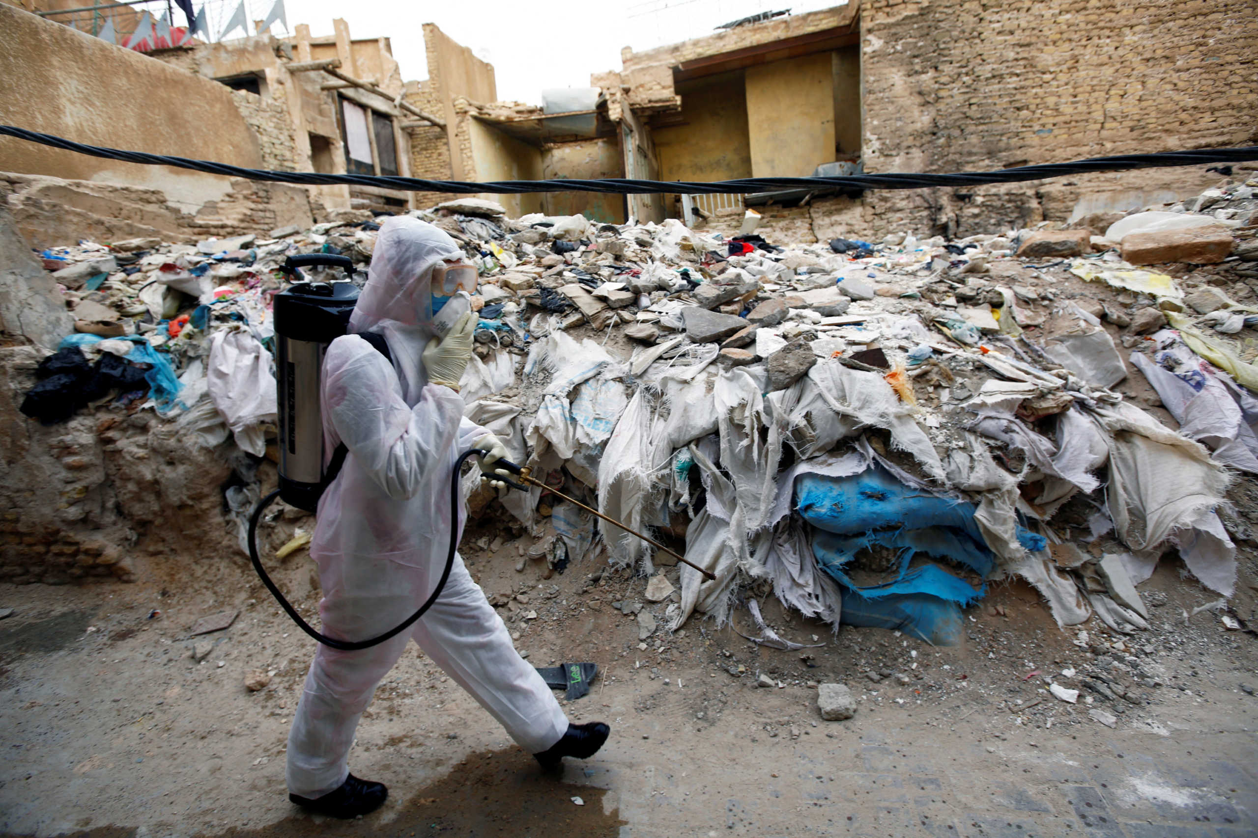 A member of the medical team sprays disinfectant to sanitize the area near a religious school where the?first?coronavirus?case?was detected, following the outbreak of the new?coronavirus, in the holy city of Najaf, Iraq February 24, 2020. REUTERS