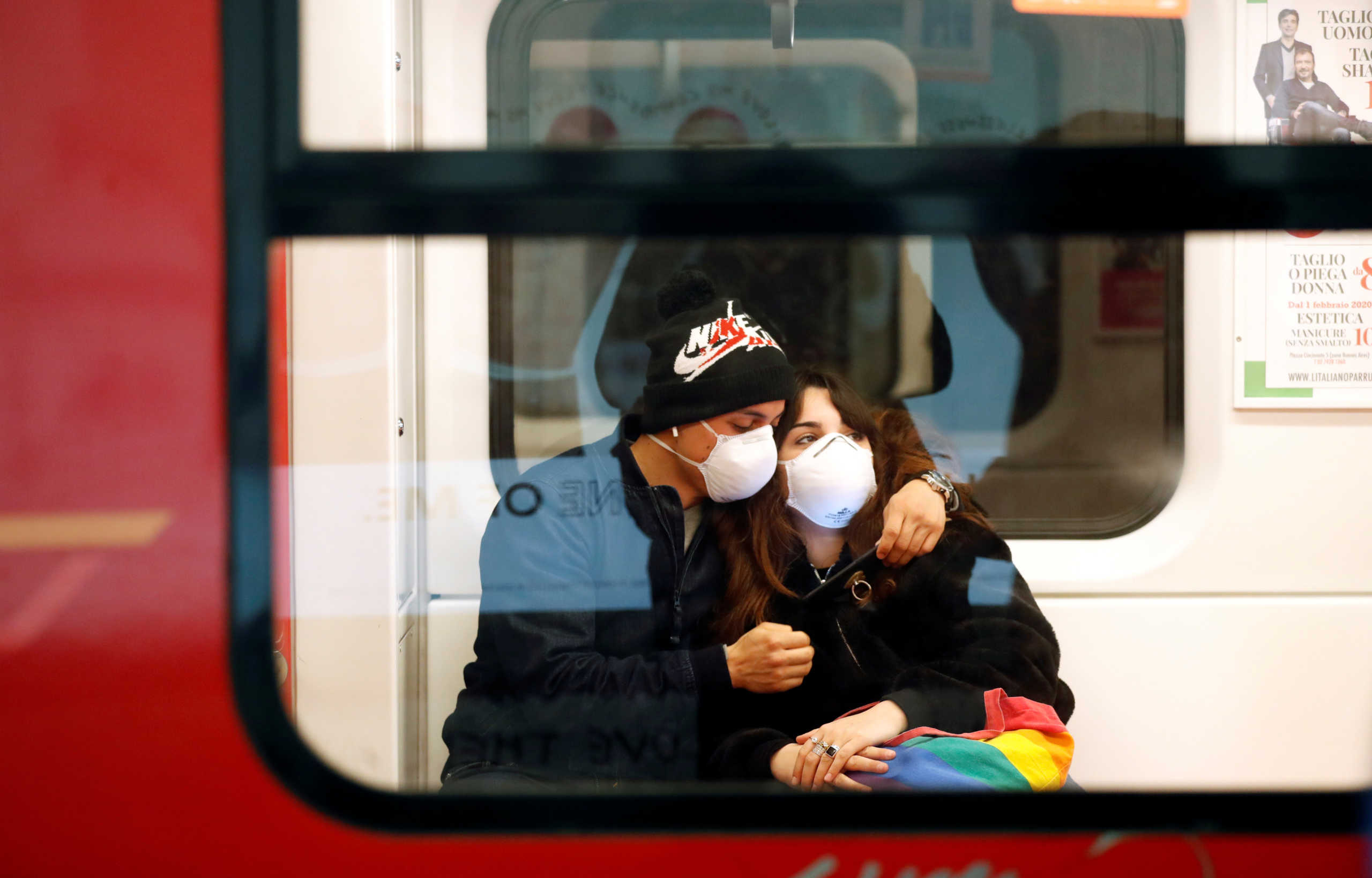 A couple wearing face masks is seen in the subway in Duomo underground station in Milan, as the country is hit by the coronavirus outbreak, Italy February 25, 2020. REUTERS