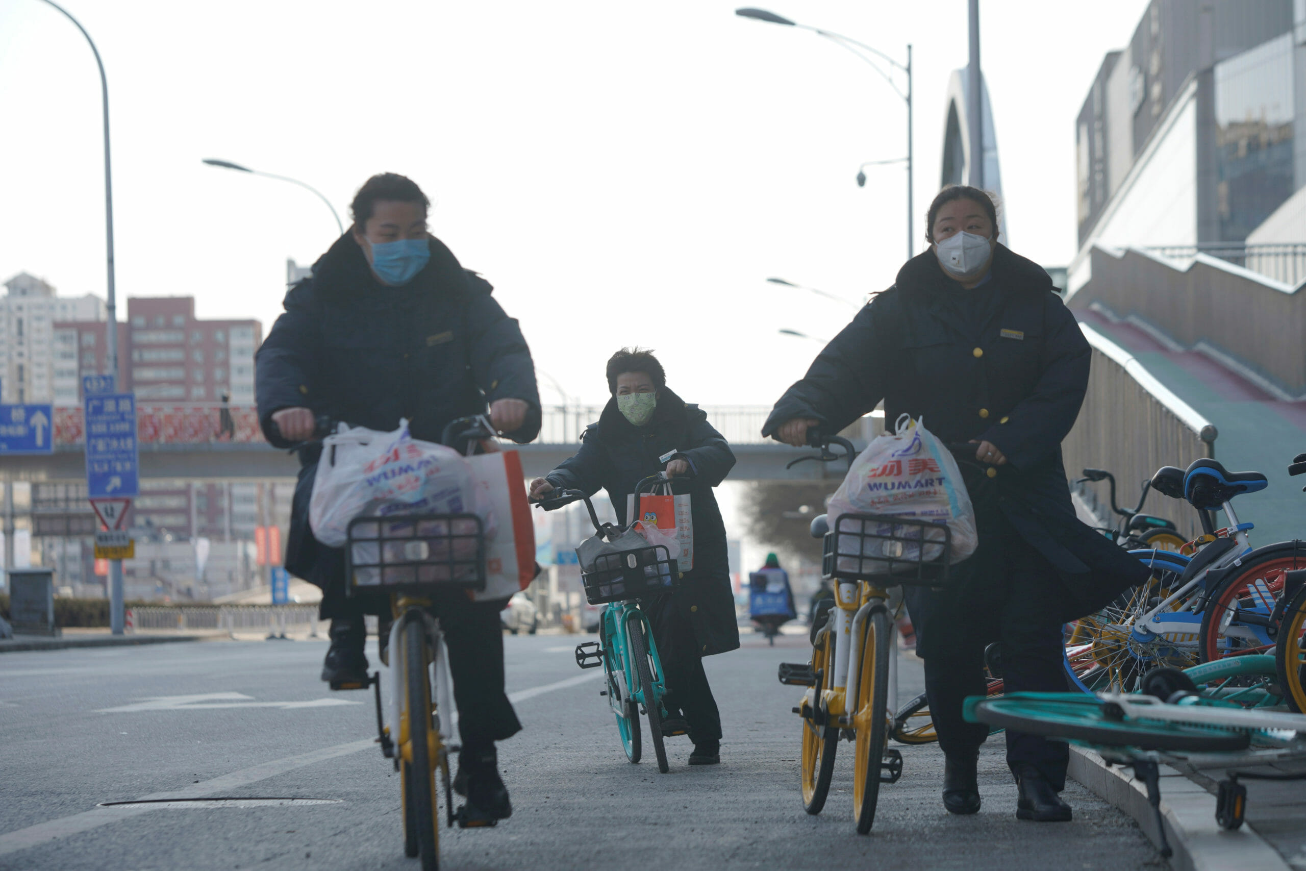 Women wearing face masks ride shared bicycles, as the country is hit by an outbreak of the novel coronavirus, in Beijing, China February 15, 2020. REUTERS