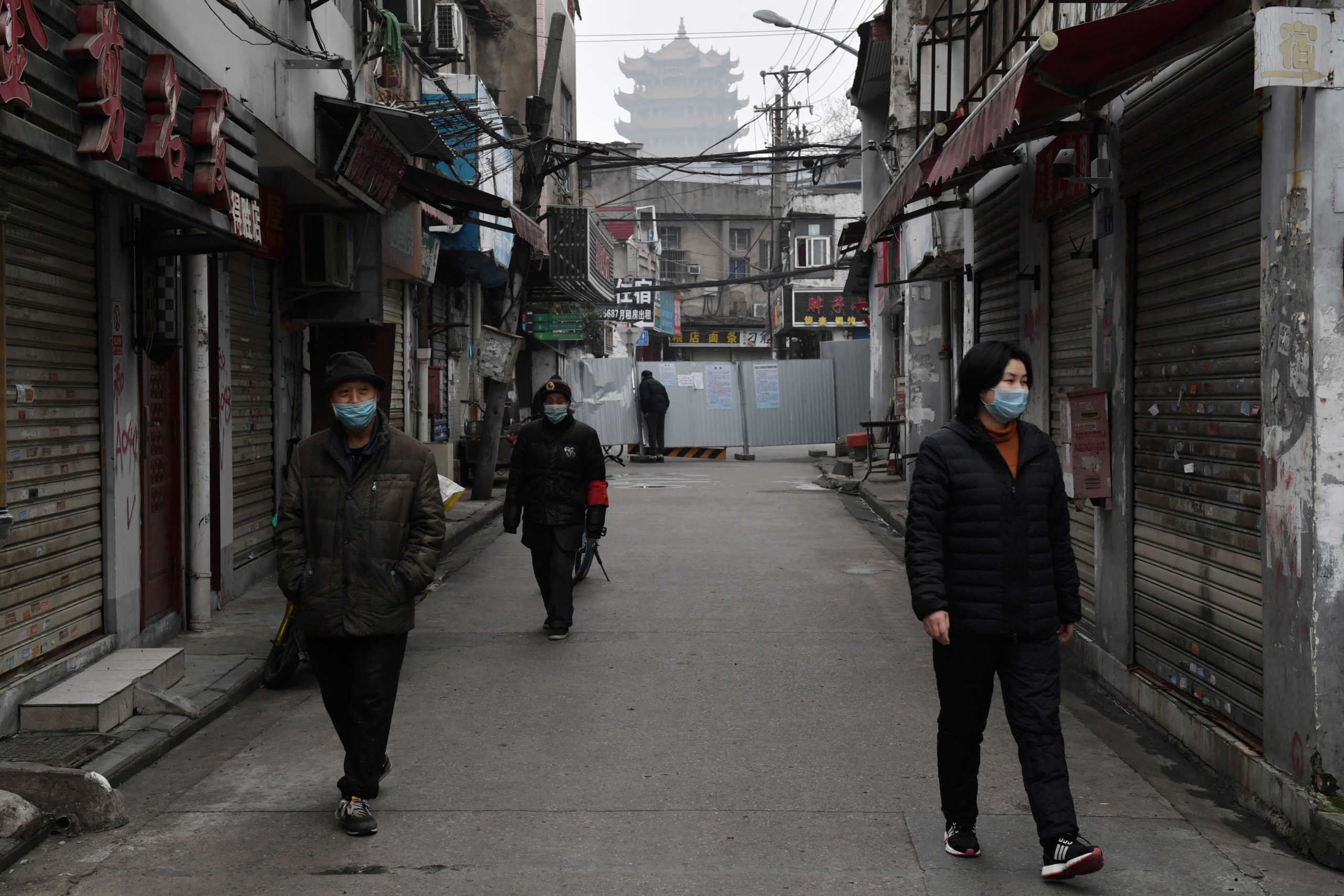 People wearing masks are seen in an alley near the Yellow Crane Tower in Wuhan, the epicentre of the novel coronavirus outbreak, Hubei province, China February 27, 2020. REUTERS