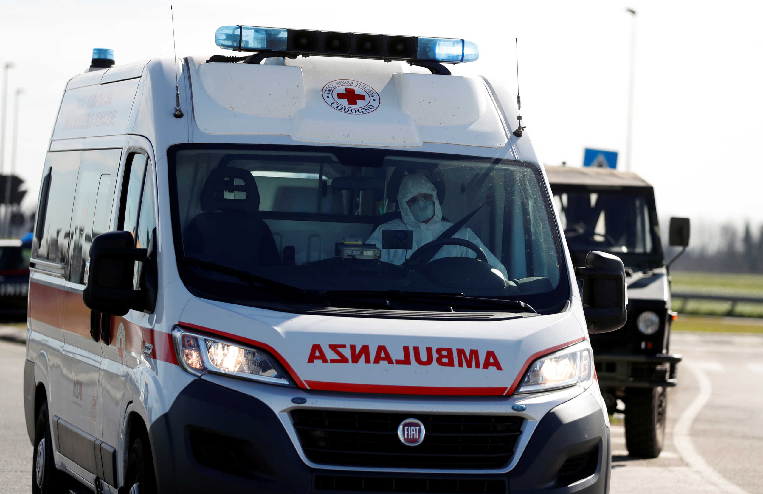 A man wearing a protective face mask drives an ambulance as he leaves the cordoned area in a "check-point six", few kilometers from the small town of Castiglione d'Adda, as a coronavirus outbreak continues to grow in northern Italy, February 27, 2020. REUTERS