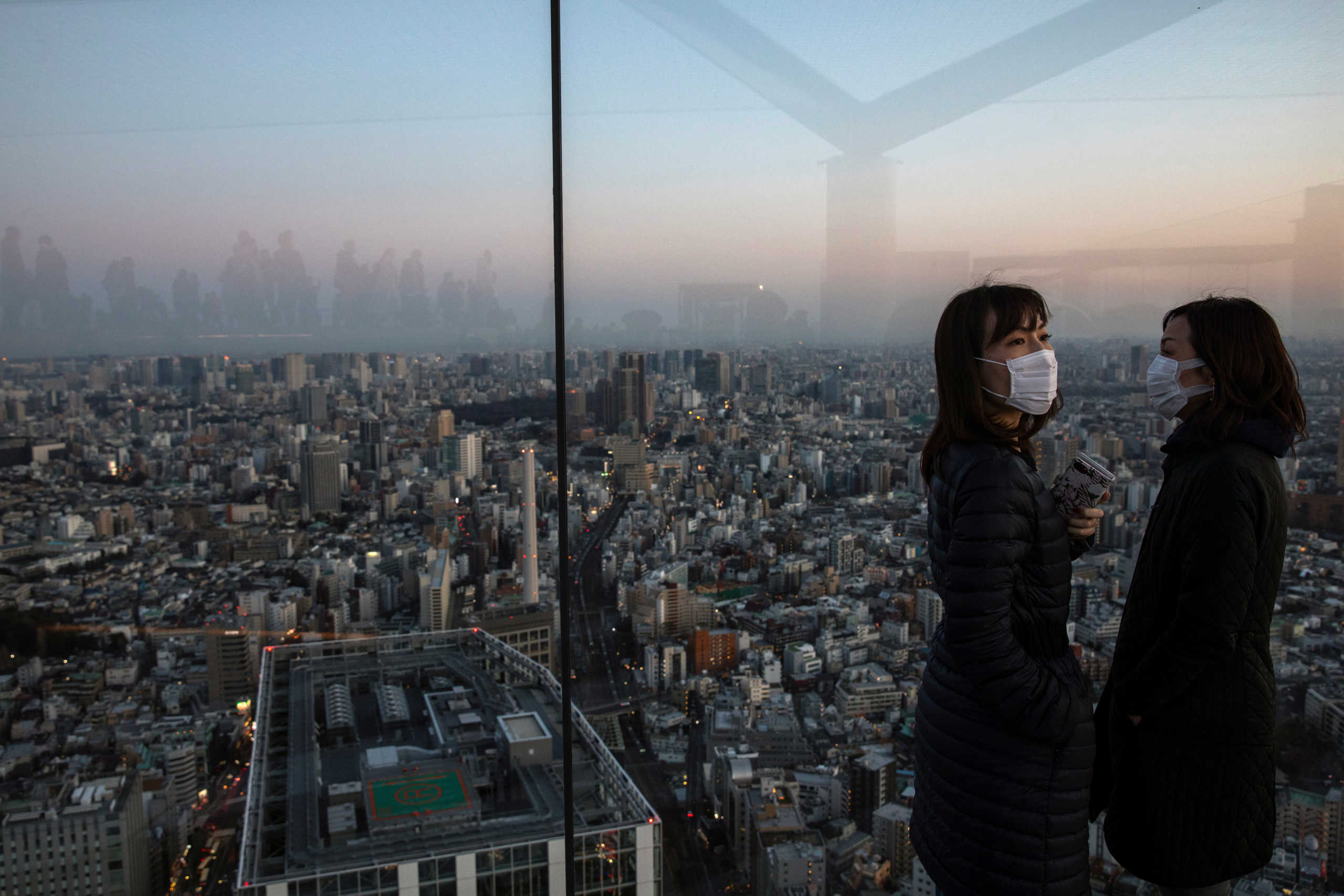 People wearing protective masks are seen at the Shibuya sky observation deck, following an outbreak of the novel coronavirus in Tokyo, Japan, February 24, 2020. REUTERS