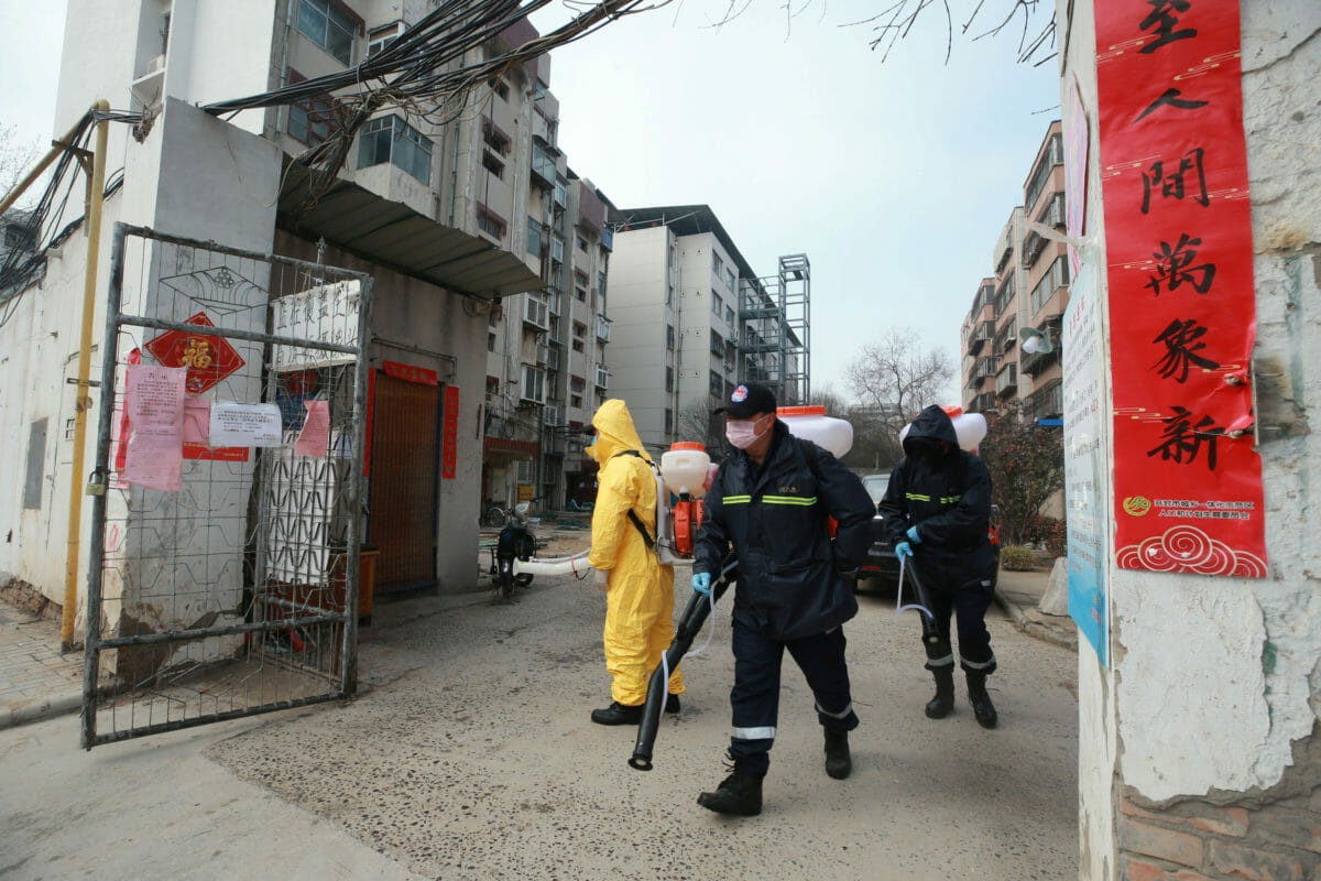 Workers with sanitizing equipment disinfect a residential compound following an outbreak of the novel coronavirus in the country, in Kaifeng, Henan province, China February 12, 2020.  cnsphoto via REUTERS   ATTENTION EDITORS - THIS IMAGE WAS PROVIDED BY A THIRD PARTY. CHINA OUT.
