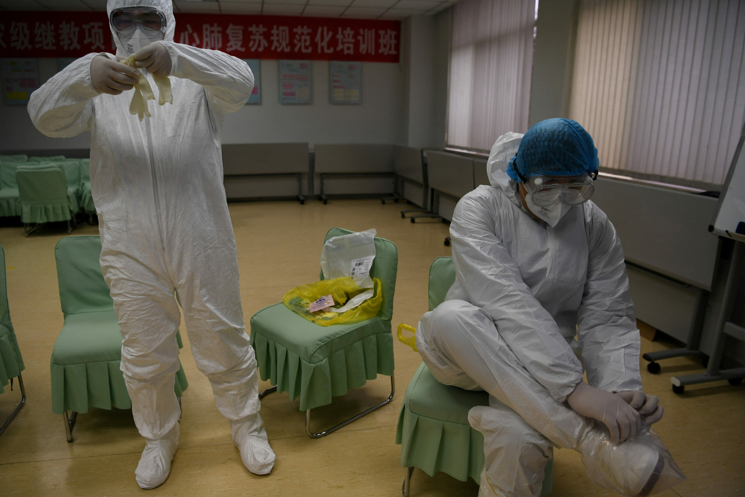 Members of a medical team tasked to transfer suspected or confirmed novel coronavirus patients to designated treatment sites put on their protective suits in Kunming, Yunnan province, China February 9, 2020. Picture taken February 9, 2020. cnsphoto via REUTERS   ATTENTION EDITORS - THIS IMAGE WAS PROVIDED BY A THIRD PARTY. CHINA OUT.