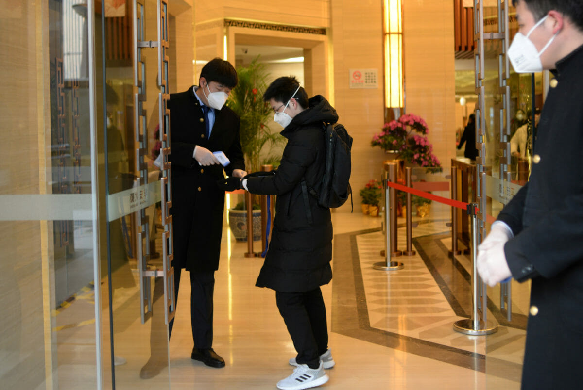 Jin Yang, 28, who works in a department of China's State Administration of Foreign Exchange, receives temperature check at an entrance to his company, in the morning on his first day of returning to work after the extended Lunar New Year holiday caused by the novel coronavirus outbreak, in Beijing, China February 10, 2020. REUTERS