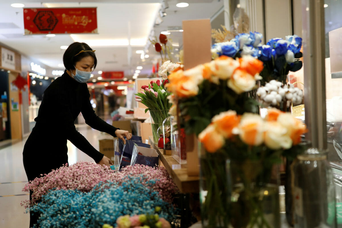 A florist who prefers to be called Cai Xiaoman wearing a face mask, works at a flowers shop in a shopping mall, as the country is hit by an outbreak of the new coronavirus, in Beijing, China February 13, 2020. REUTERS
