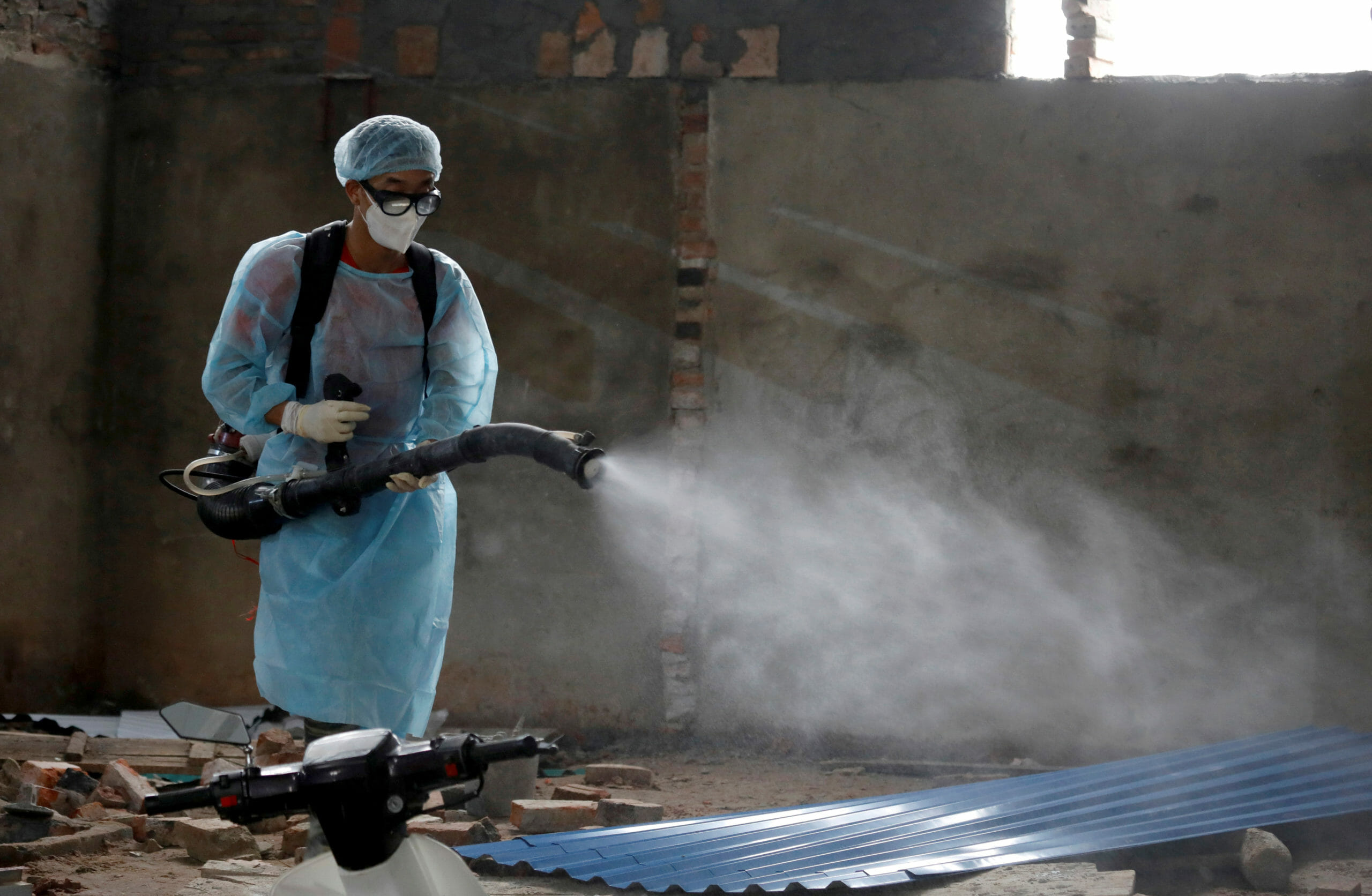 A Vietnamese health worker sprays chemicals to disinfect an area in Vinh Phuc province, Vietnam February 12, 2020. REUTERS