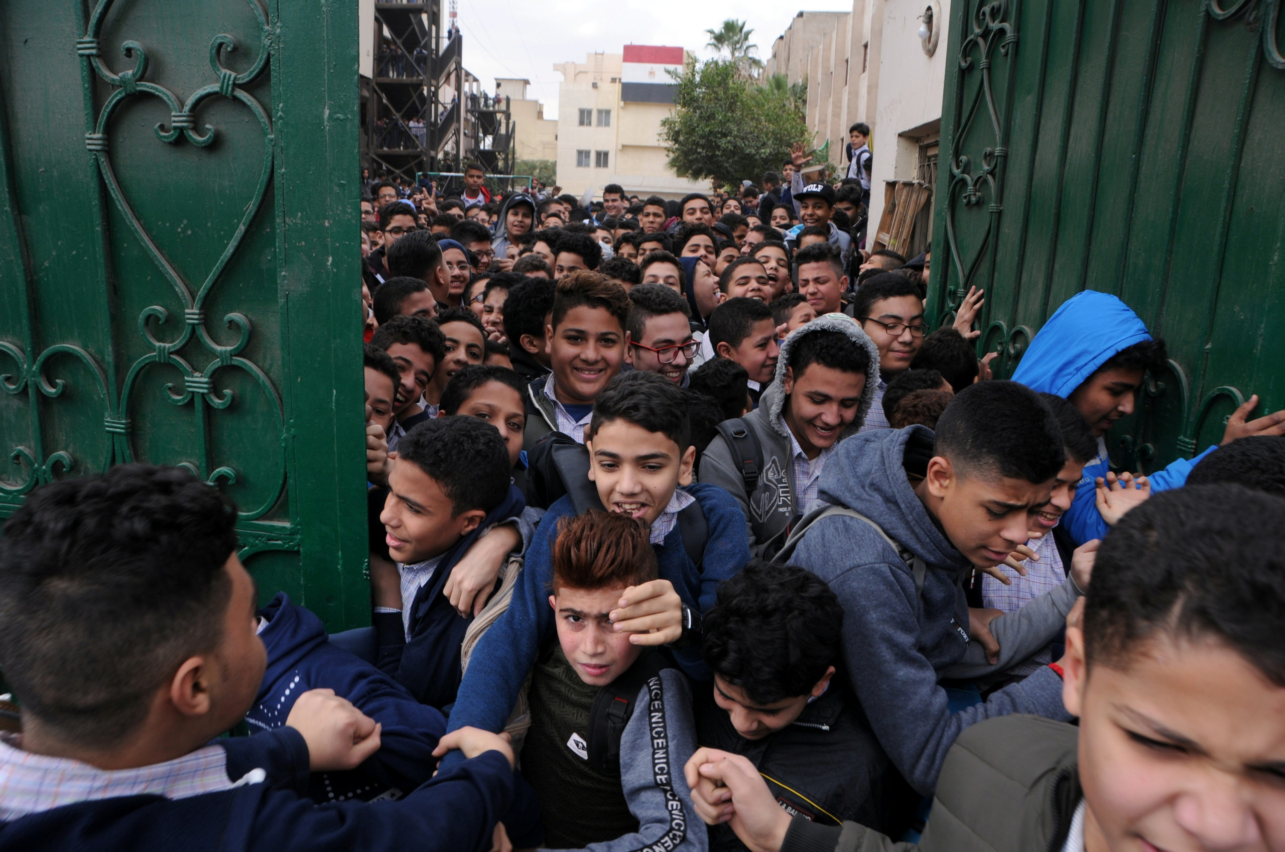 Boys get out from the gate of a school in Cairo, Egypt February 9, 2020. Egypt's population has now reached 100 million and according to Aleksandar Bodiroza, representative of the U.N, the pressure Egypt faces is acute. 97% of its people live on just 8% of its territory, crowded along the Nile, Egypt's population is growing by 2.5 million people a year and six people in ten are under 29 years old. Picture taken February 9, 2020. REUTERS