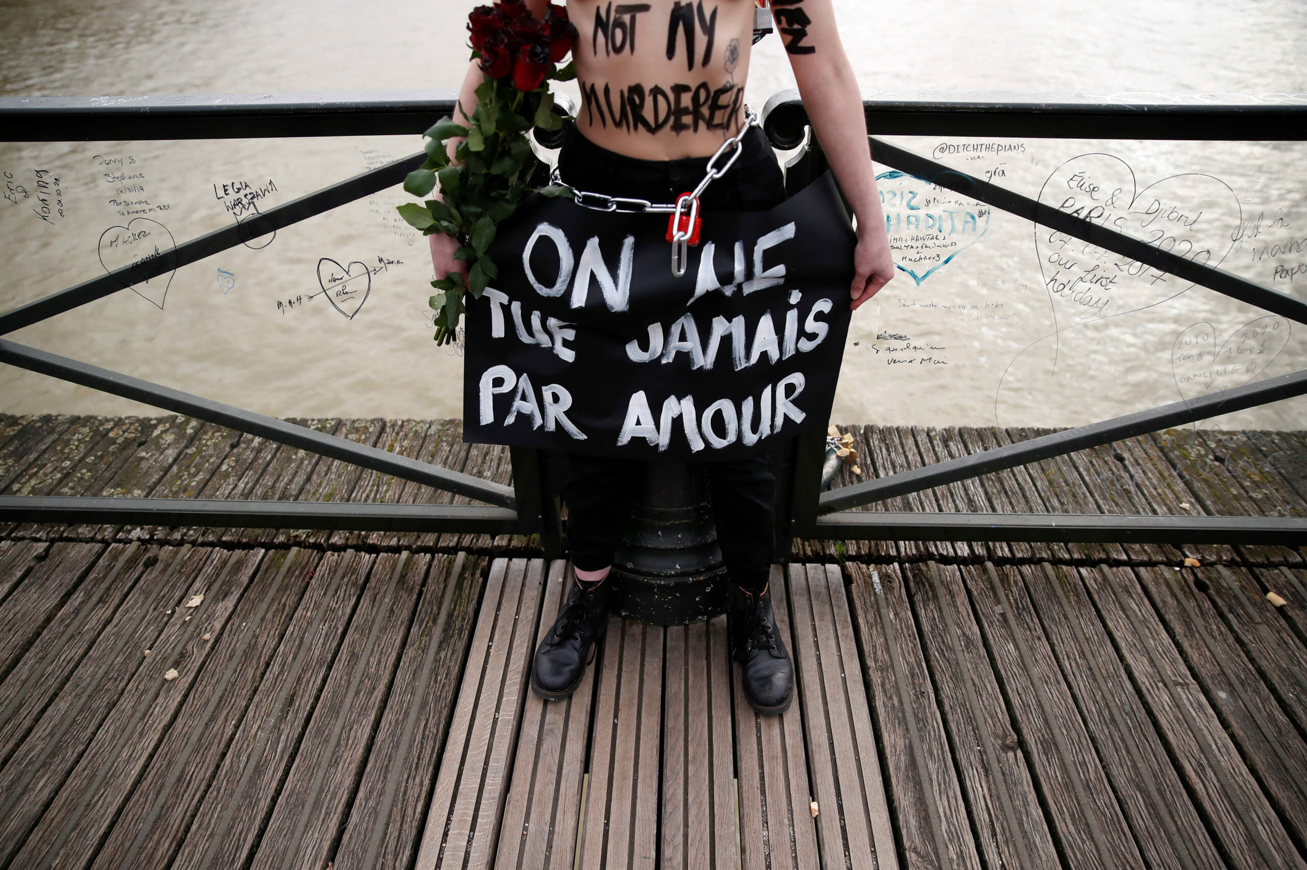 A Femen activist stages an action on the Pont des Arts to protest violence against women on Valentine's Day in Paris, France, February 14, 2020. The slogan reads "We never kill for love". REUTERS