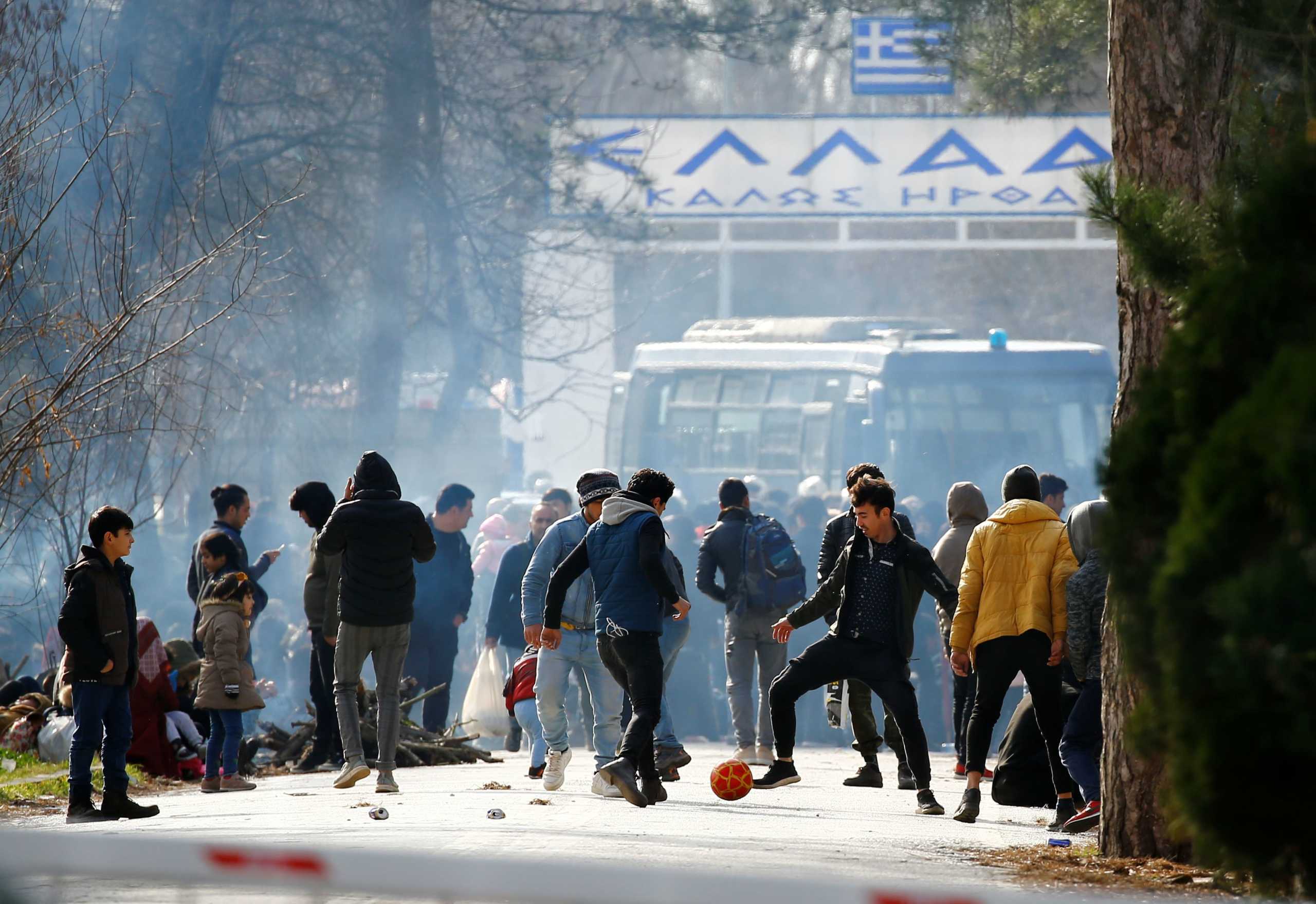 A picture taken from Pazarkule shows a group of migrants waiting on no man's land between Turkey and Greece, at the Turkeys Pazarkule border crossing with Greece's Kastanies, in Turkey, February 28, 2020. REUTERS