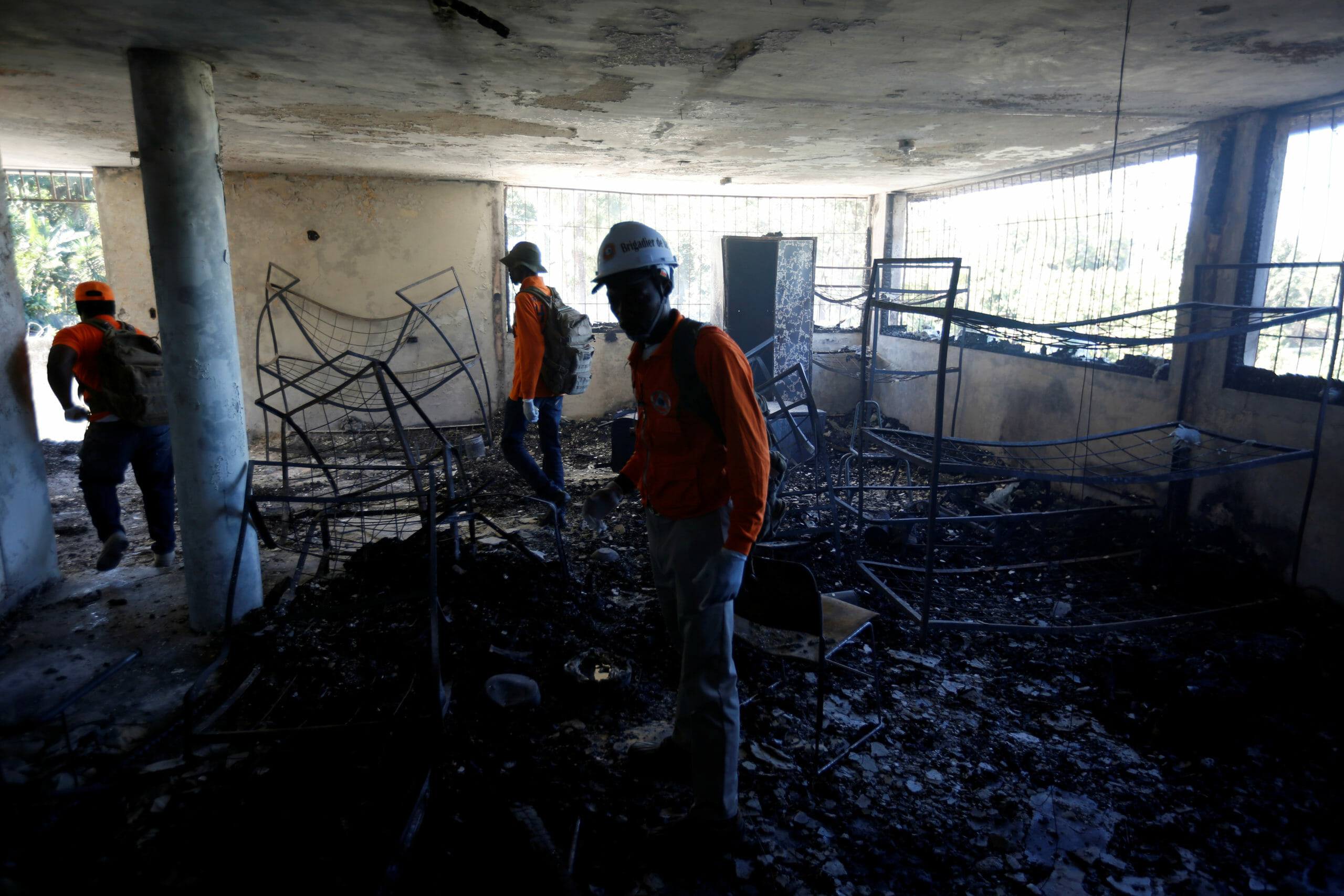 Civil protection workers stand inside a bedroom at an orphanage after it was destroyed in a fire, in Port-au-Prince, Haiti, February 14, 2020. REUTERS