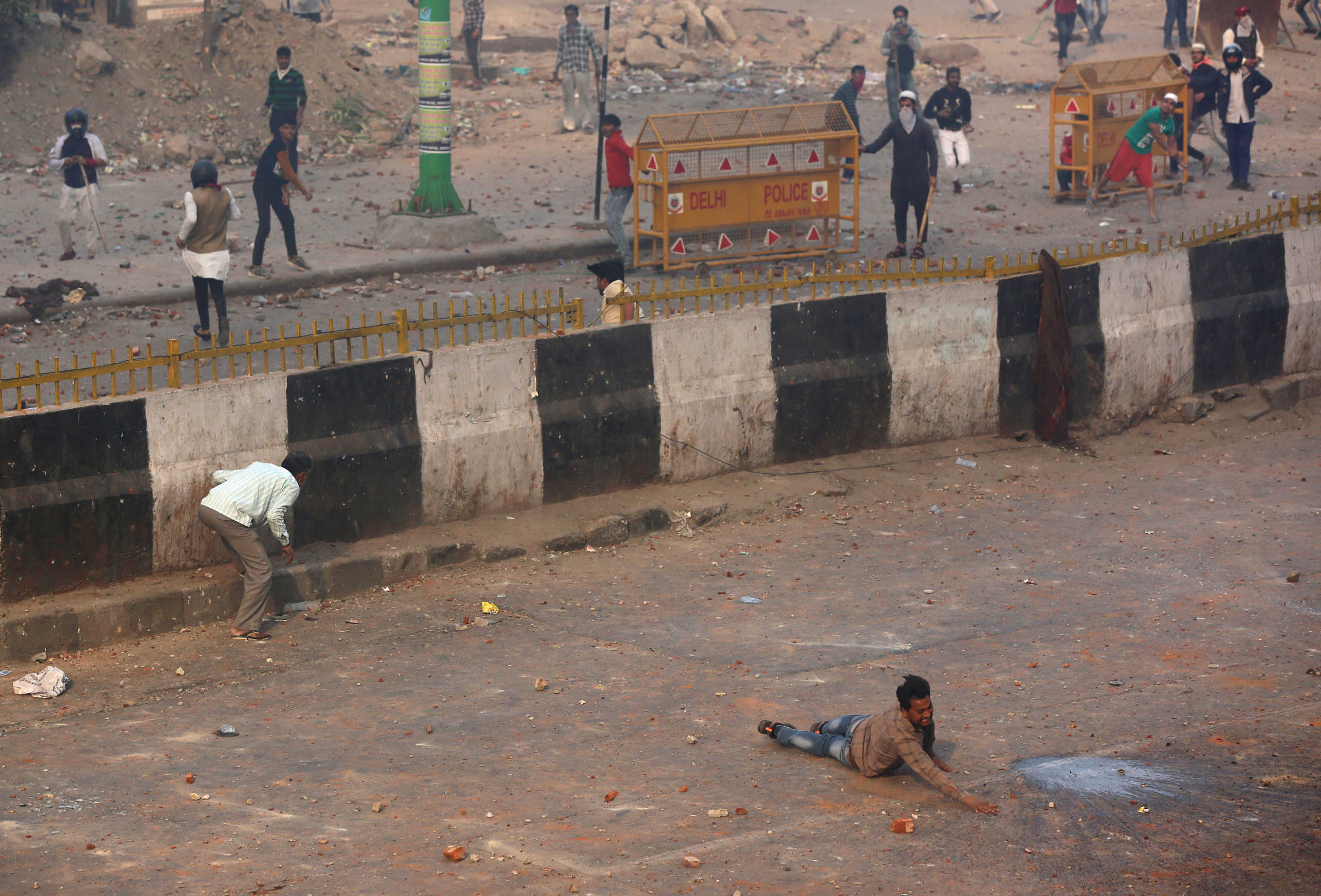 A man reacts as he falls during a clash between people supporting a new citizenship law and those opposing the law in New Delhi, India, February 24, 2020. Picture taken February 24, 2020. REUTERS