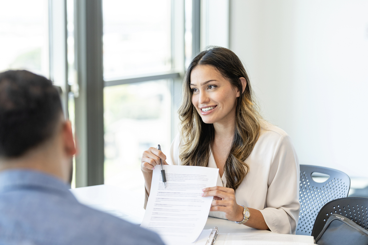 A confident mid adult female loan shows a male customer a
