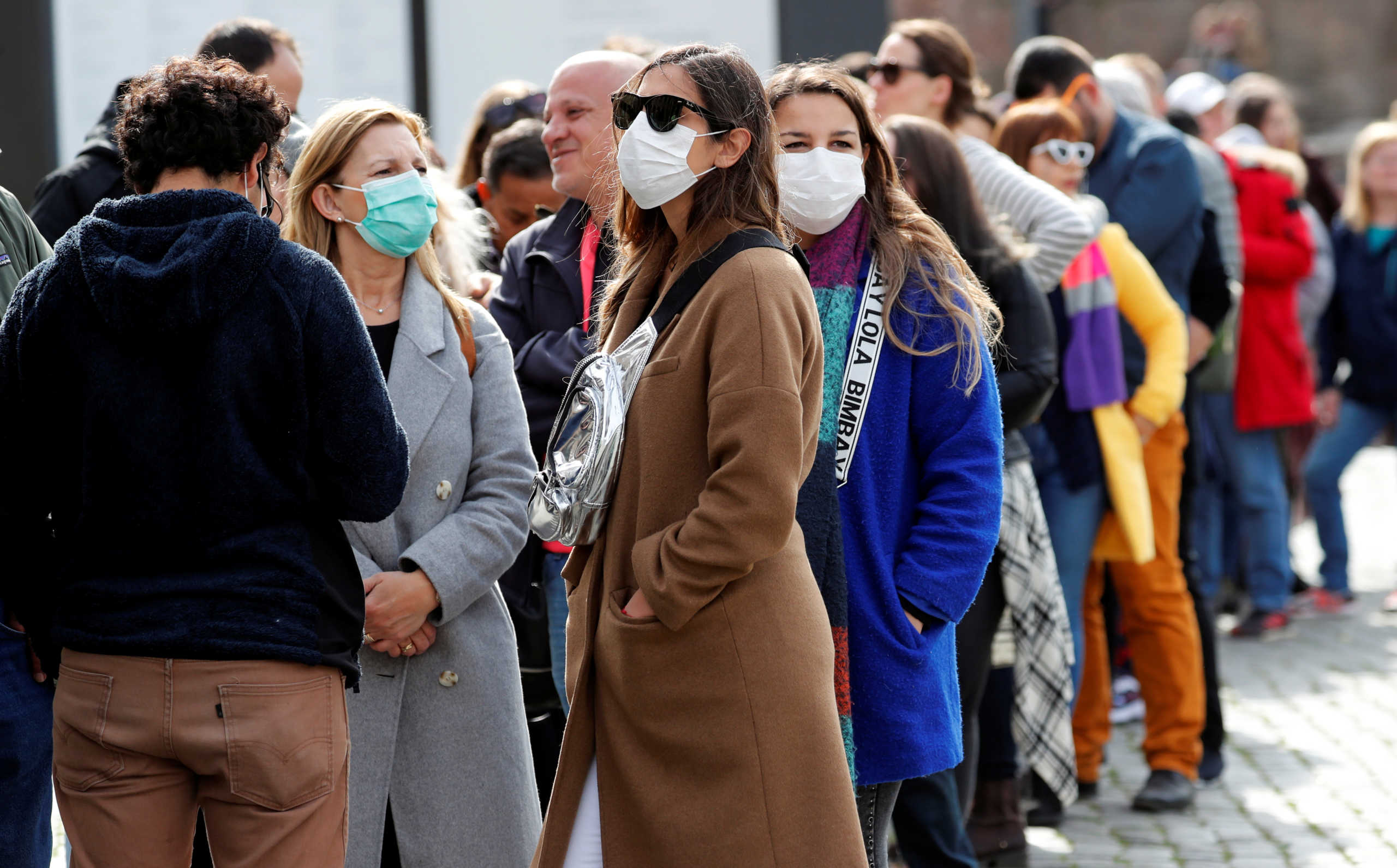 People wearing protective masks queue to enter the Colosseum in Rome, Italy, February 25, 2020. REUTERS