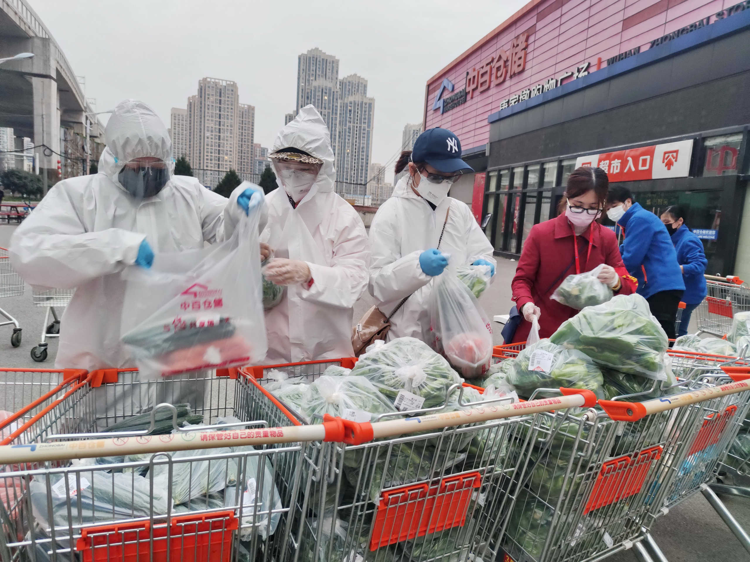 Community workers and volunteers wearing face masks sort and pack groceries from a supermarket purchased through group orders following supermarkets stop selling to individuals, in Wuhan, the epicentre of the novel coronavirus outbreak, in Hubei province, China February 24, 2020. Picture taken February 24, 2020. China Daily via REUTERS ATTENTION EDITORS - THIS IMAGE WAS PROVIDED BY A THIRD PARTY. CHINA OUT.