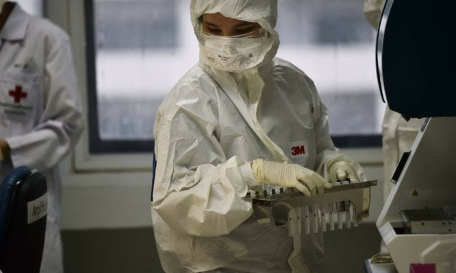 Lab technicians test patient samples for the novel coronavirus at the Centre for Emerging Infectious Diseases of Thailand at Chulalongkorn University in Bangkok on February 5, 2020. - Thailand so far has detected 25 confirmed cases of the novel coronavirus believed to have originated in the central Chinese city of Wuhan, which is under lockdown. (Photo by Lillian SUWANRUMPHA