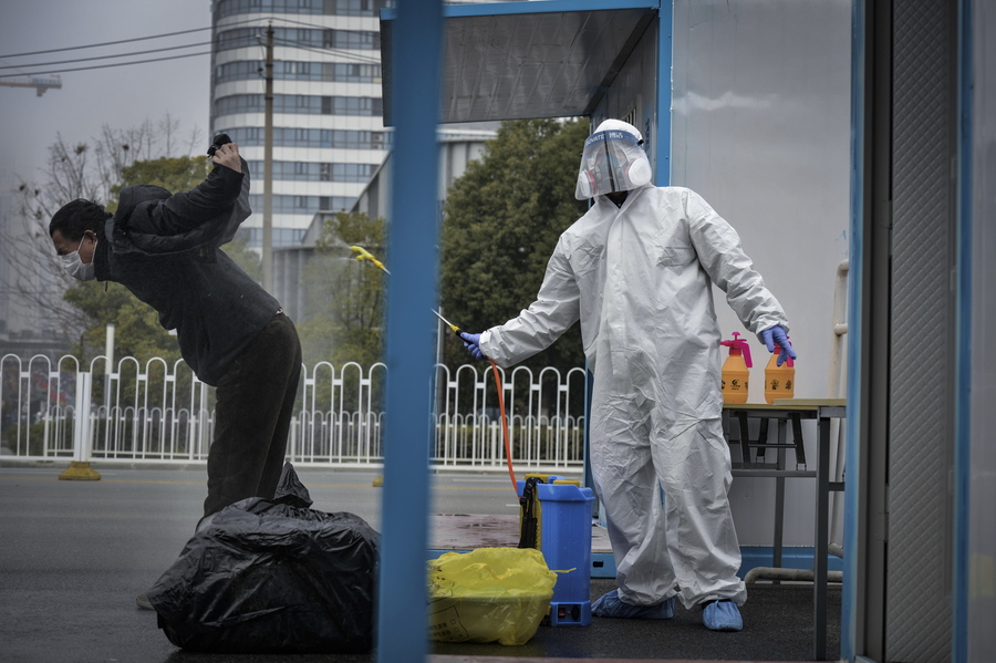 epaselect epa08242603 A worker disinfects a recovered COVID-19 patient departing a temporary hospital in Wuhan, Hubei province, China, 22 February 2020 (issued 24 February 2020). The outbreak of Covid-19 and the coronavirus, which is believed to have originated in the Chinese city of Wuhan, has so far killed at least 2,467 people and infected over 78,000 others worldwide.  EPA